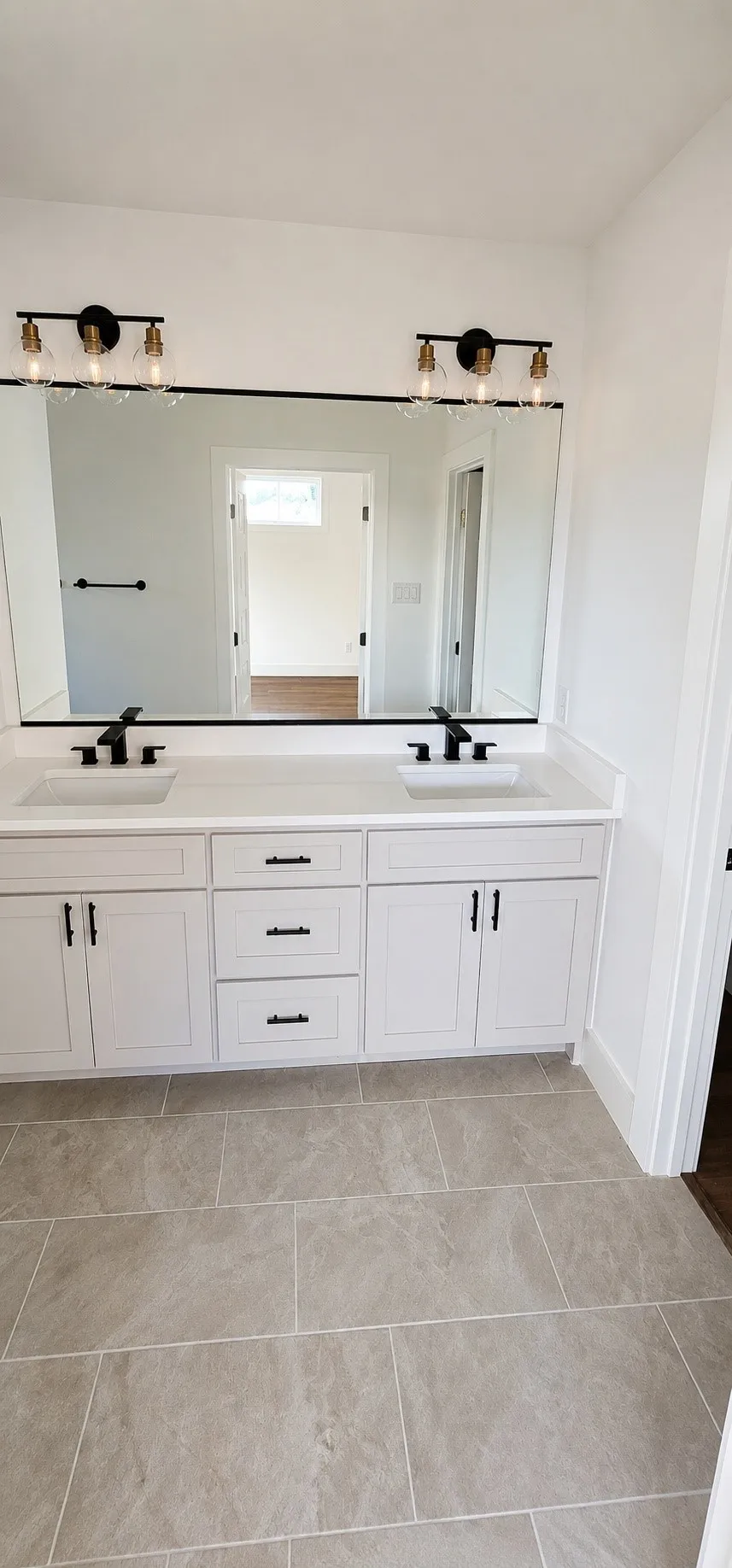 Dual vanity with white cabinetry and black hardware