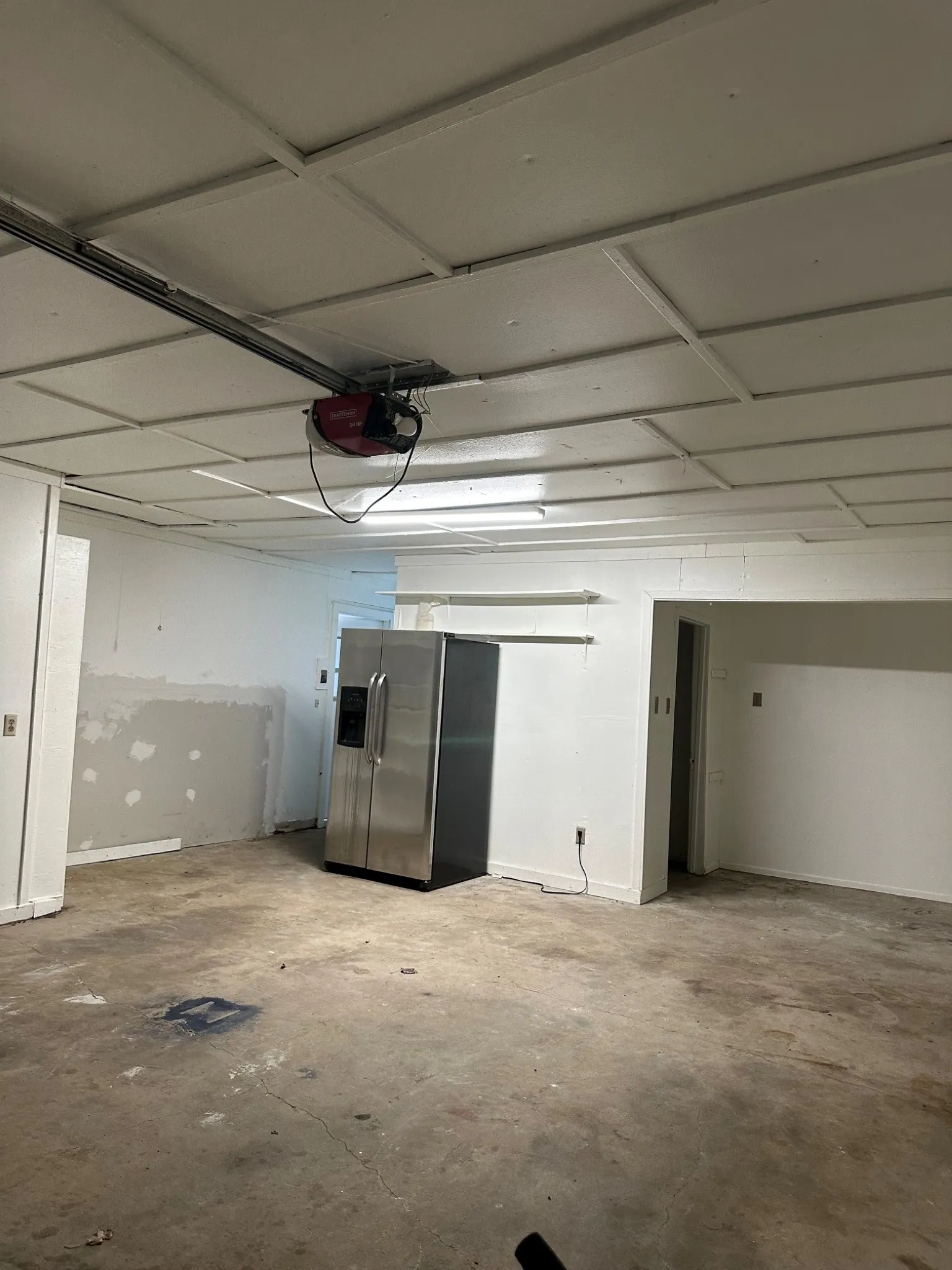 Garage looking at work area and hallway to house