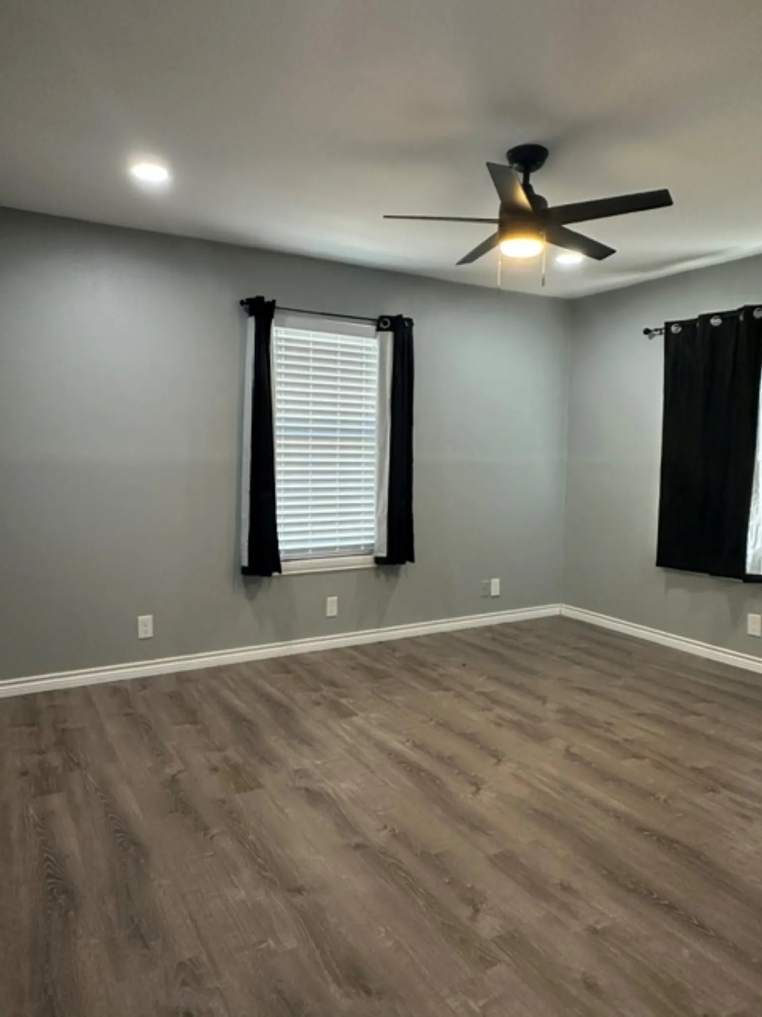 Front bedroom with ceiling fan and spots