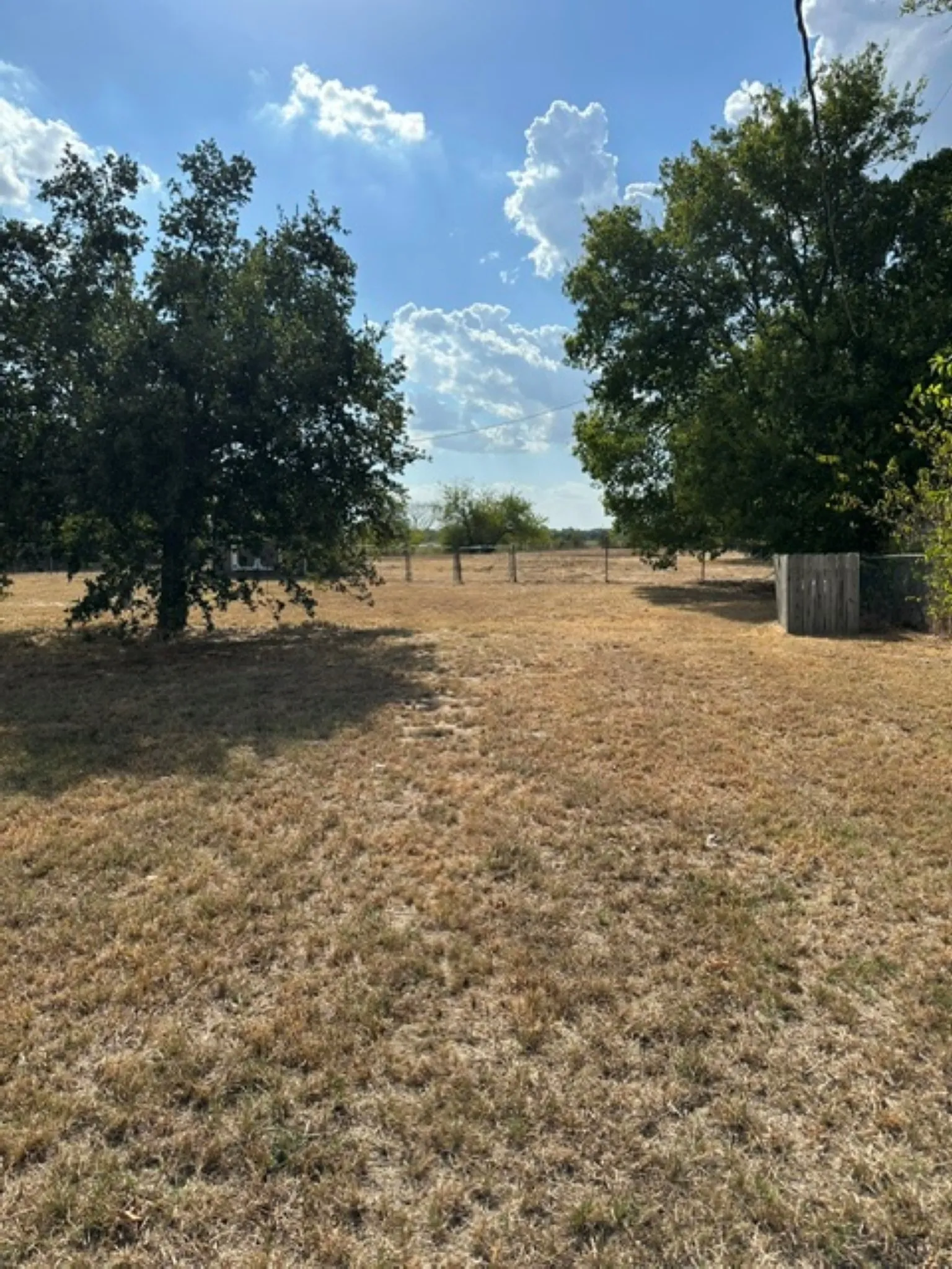 Fenced back yard with storage building