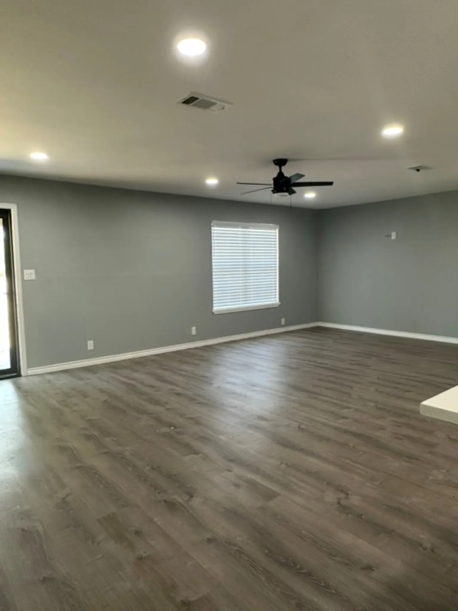 Open living area with recessed lighting, fan, & blinds