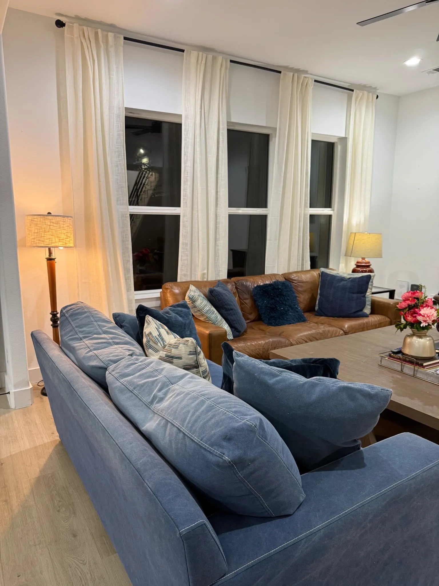 Wood-finish flooring, multiple windows with roller shades, and recessed lighting