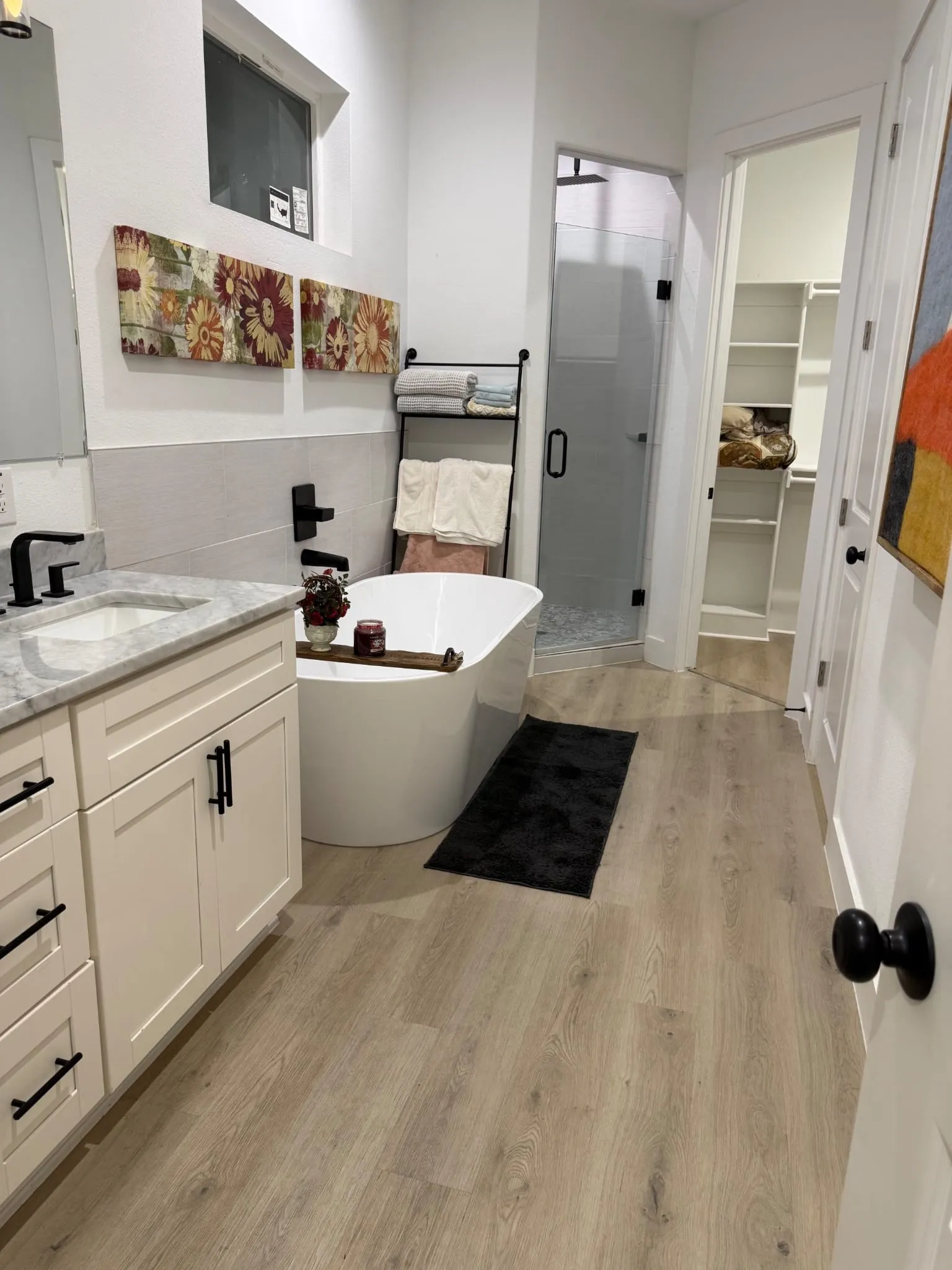 White vanity with black hardware and stone countertop
