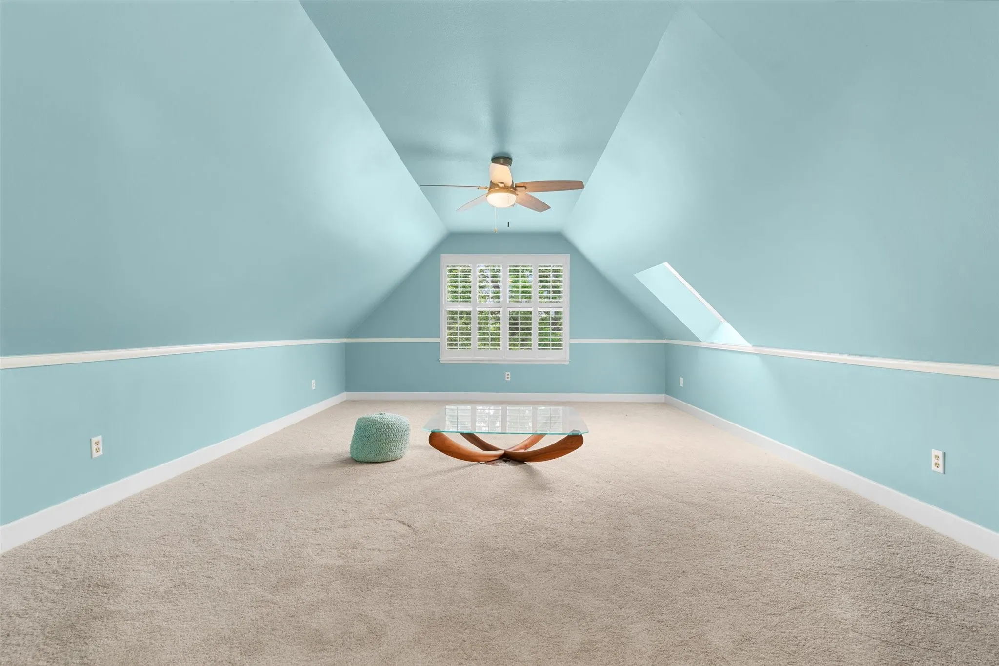 Recessed window with plantation shutters, vaulted ceiling, and ceiling fan