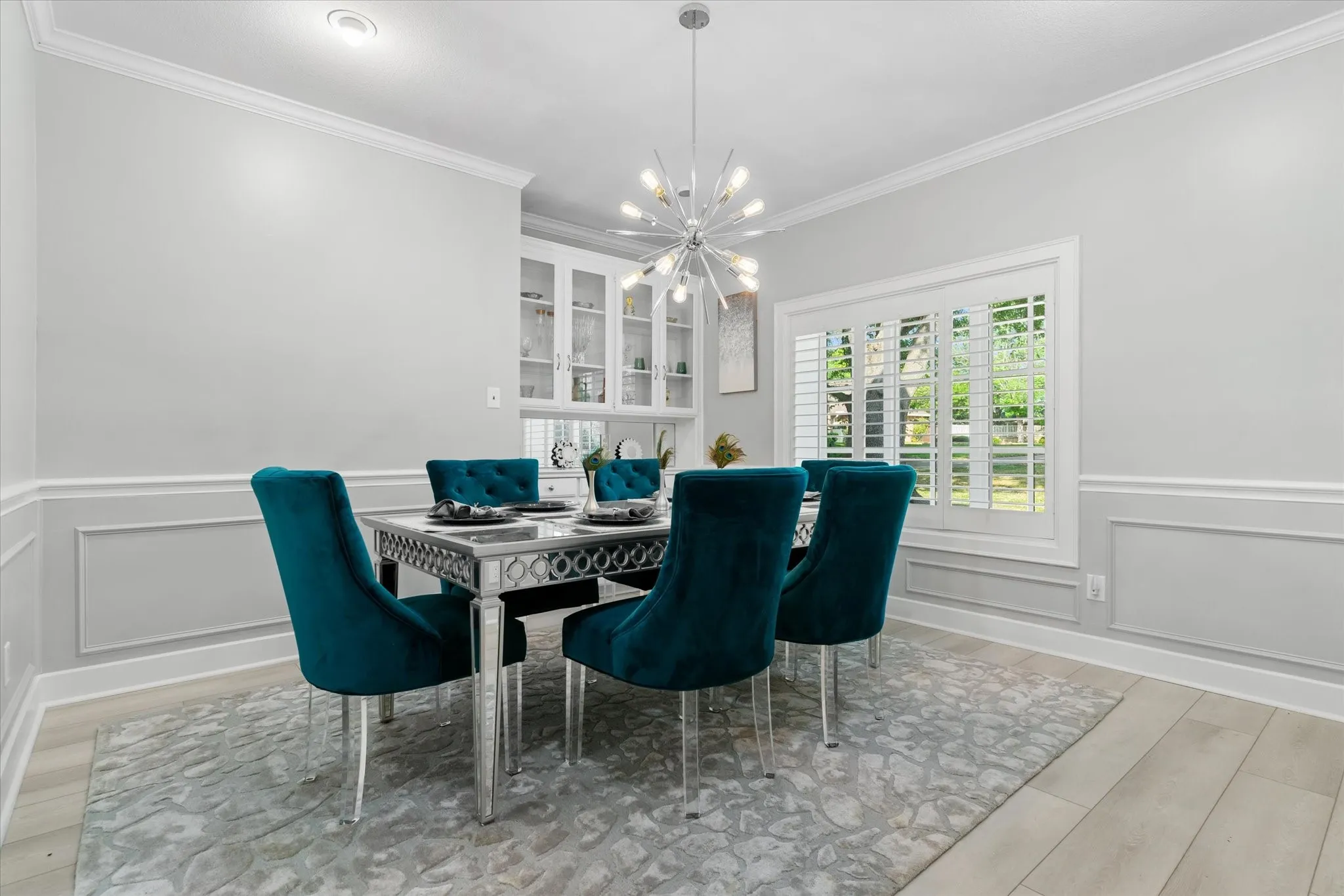 Recessed lighting and a decorative chandelier illuminate the space