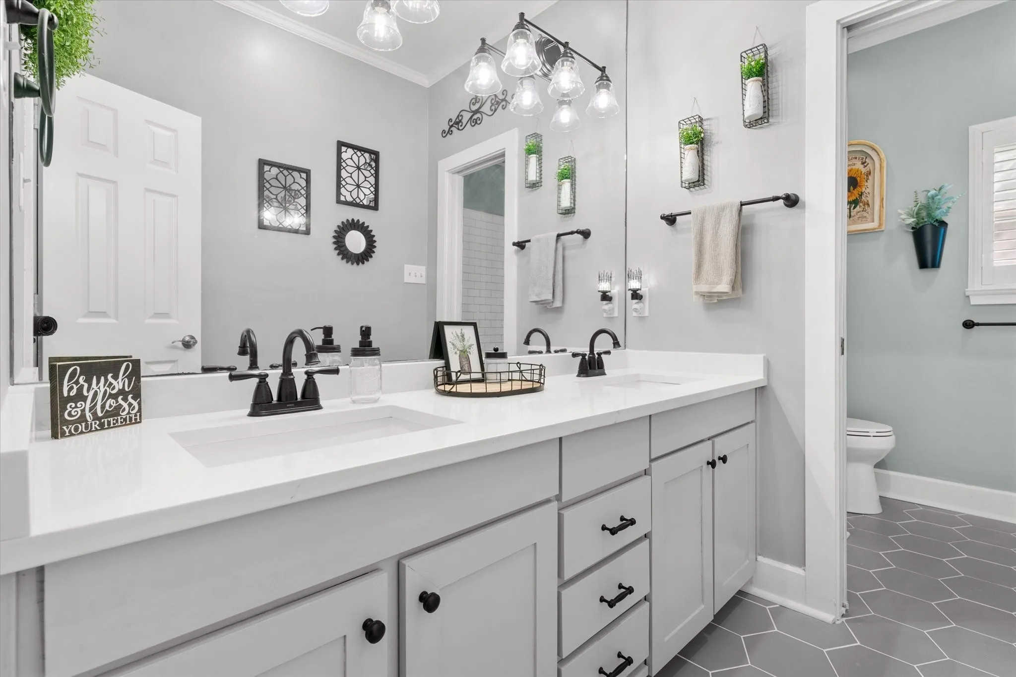 Dual vanity with matte black fixtures, white countertop, and light gray cabinetry