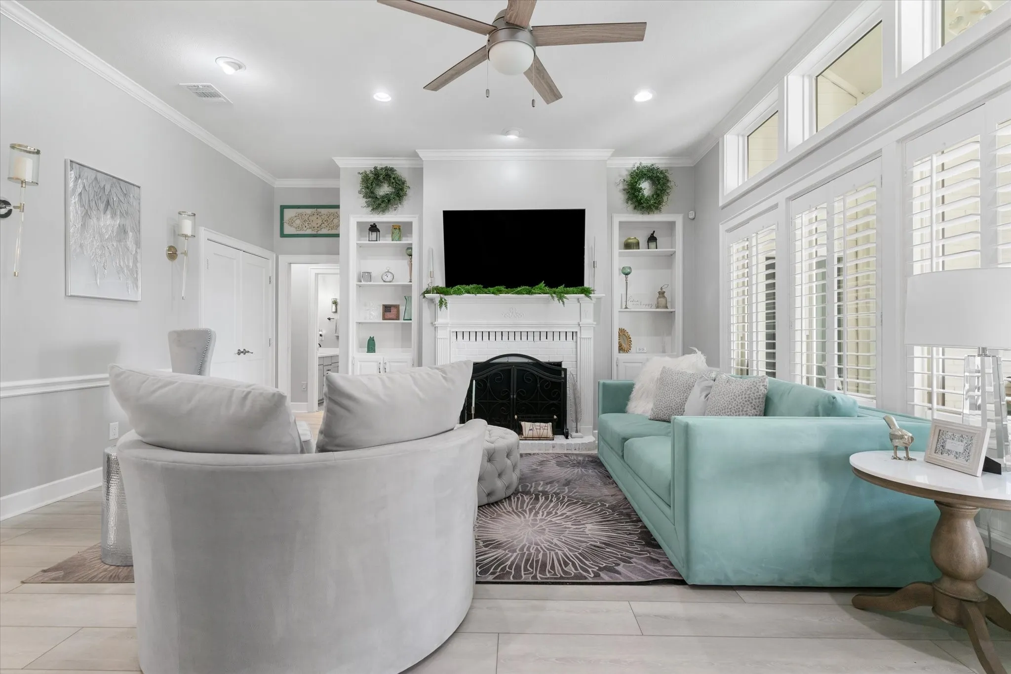 Living area featuring a ceiling fan, recessed lighting, wood-finish flooring, a fireplace with a mantel, and built-in shelving