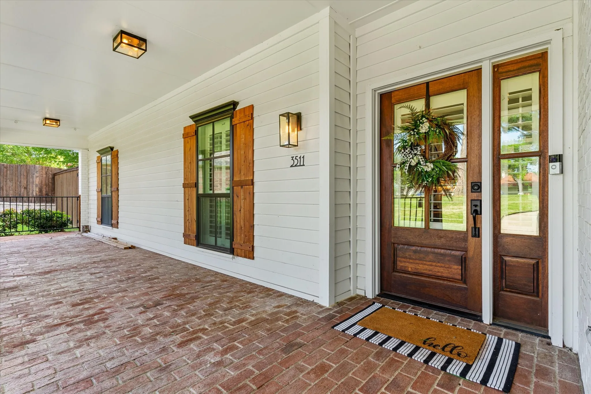 White siding exterior with a covered brick-paver porch