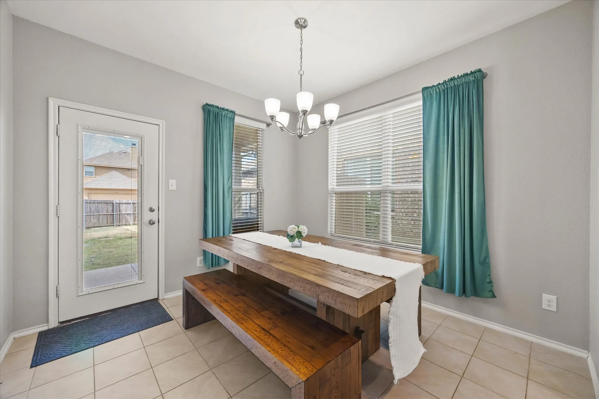 Tile flooring, a full-lite exterior door, and a multi-light chandelier