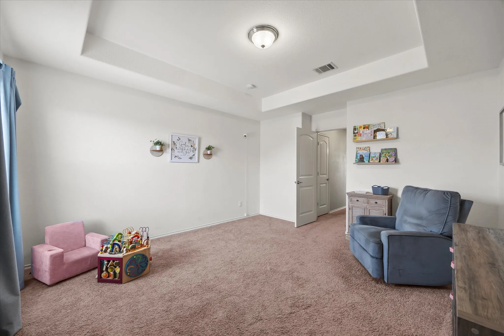 Tray ceiling, flush-mount lighting, wall-mounted shelving, six-panel interior doors, and carpet flooring