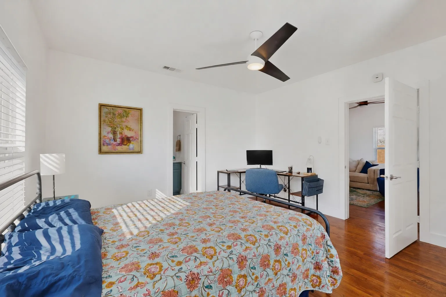 Hardwood-finish flooring, white walls, and a ceiling fan with integrated lighting