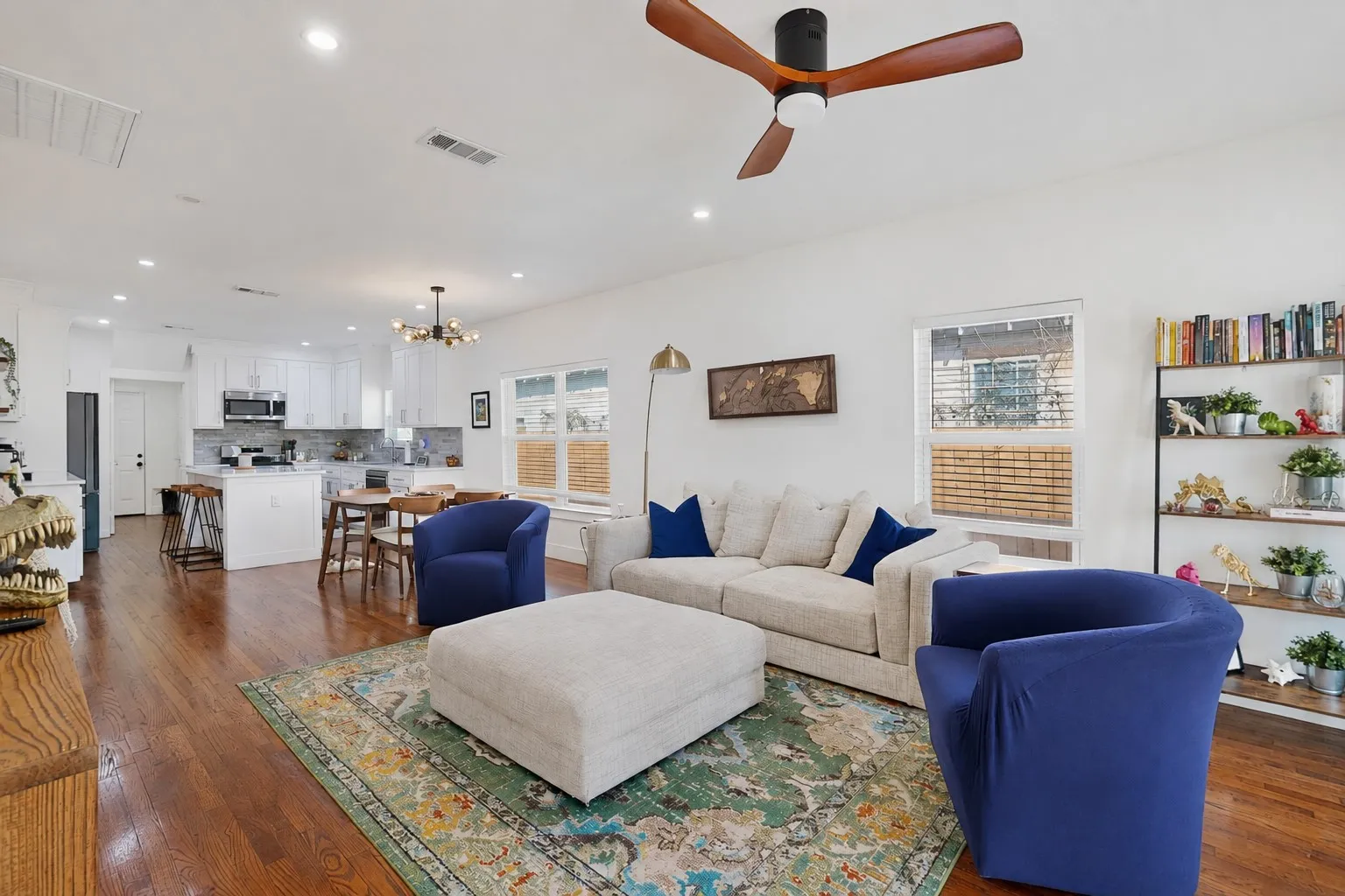 Open-concept living area with wood-finish flooring, recessed lighting, and a ceiling fan