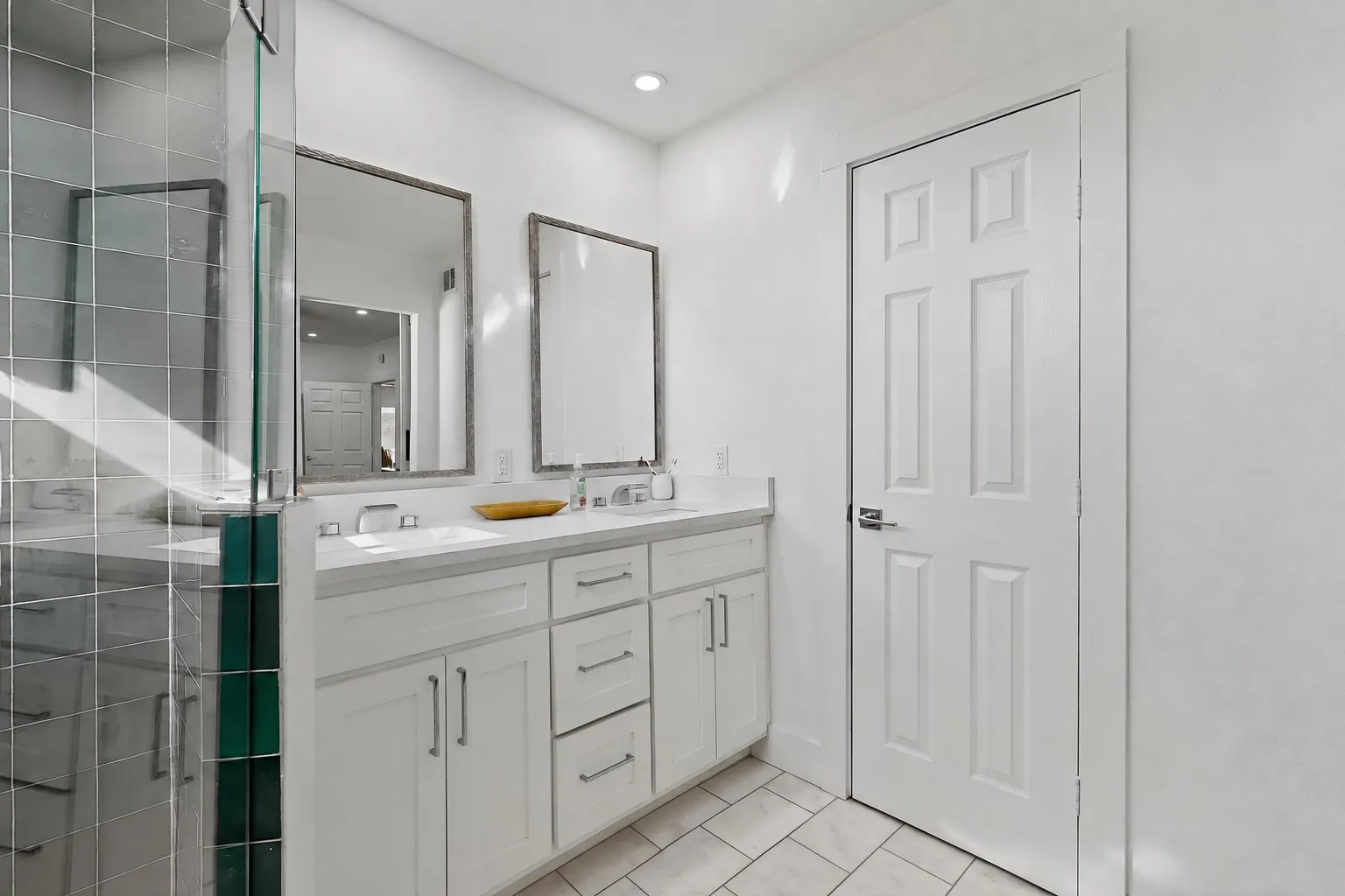 Dual vanity with undermount sinks, white cabinetry, and polished chrome fixtures