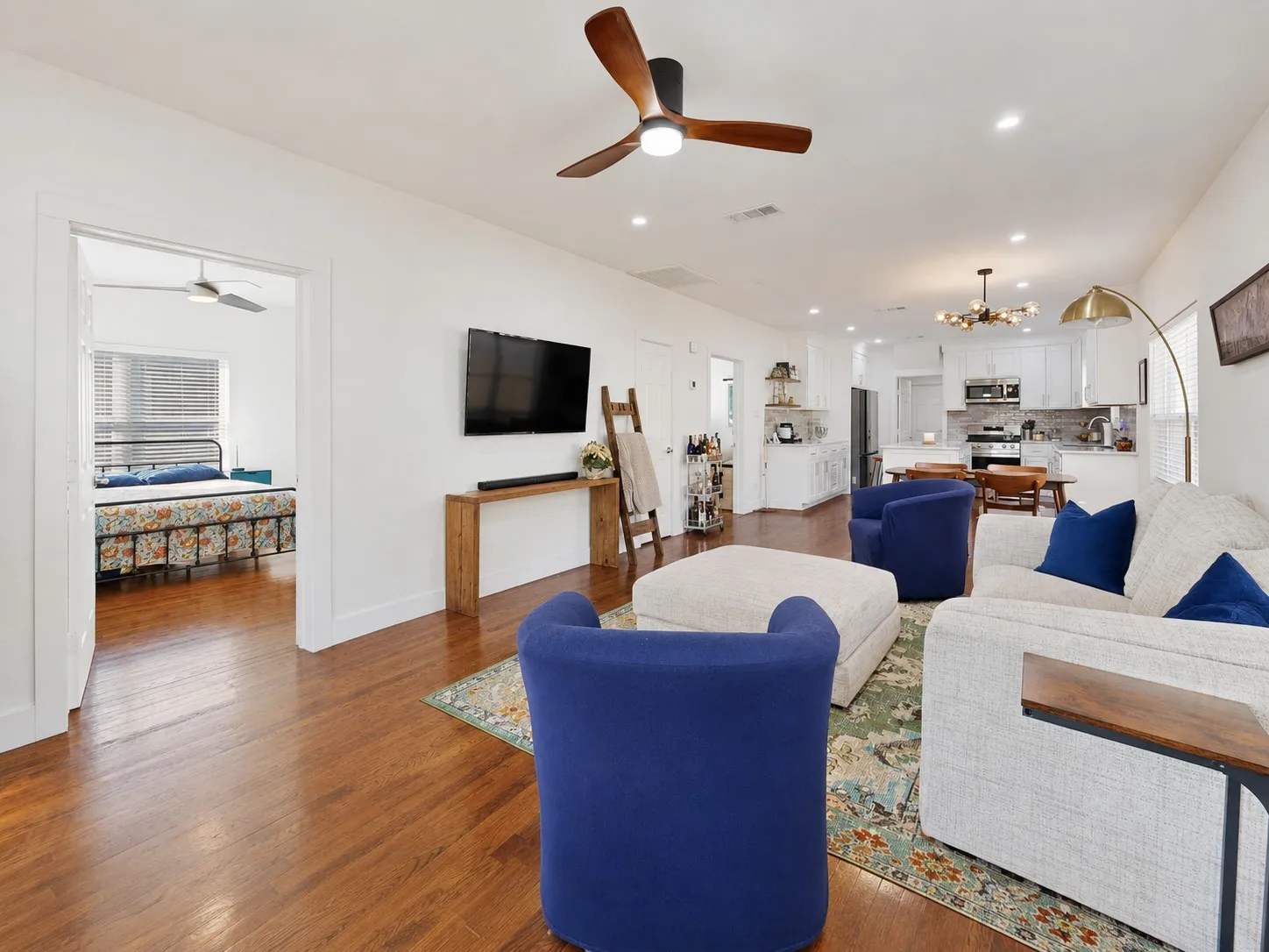 Open-concept living space featuring wood-finish flooring, recessed lighting, and a contemporary ceiling fan