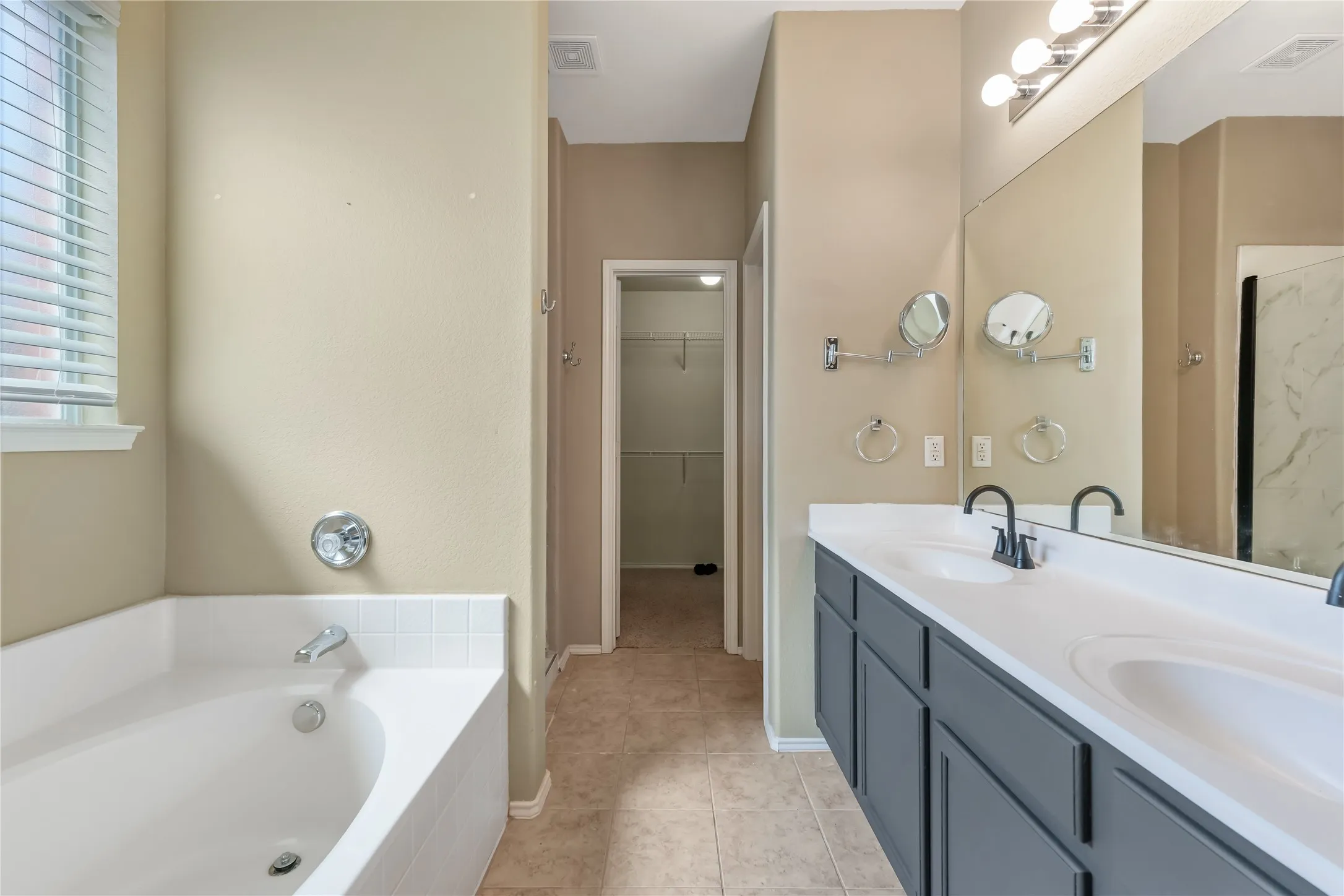 Dual vanity with integrated sinks, matte black faucets, and a large mirror
