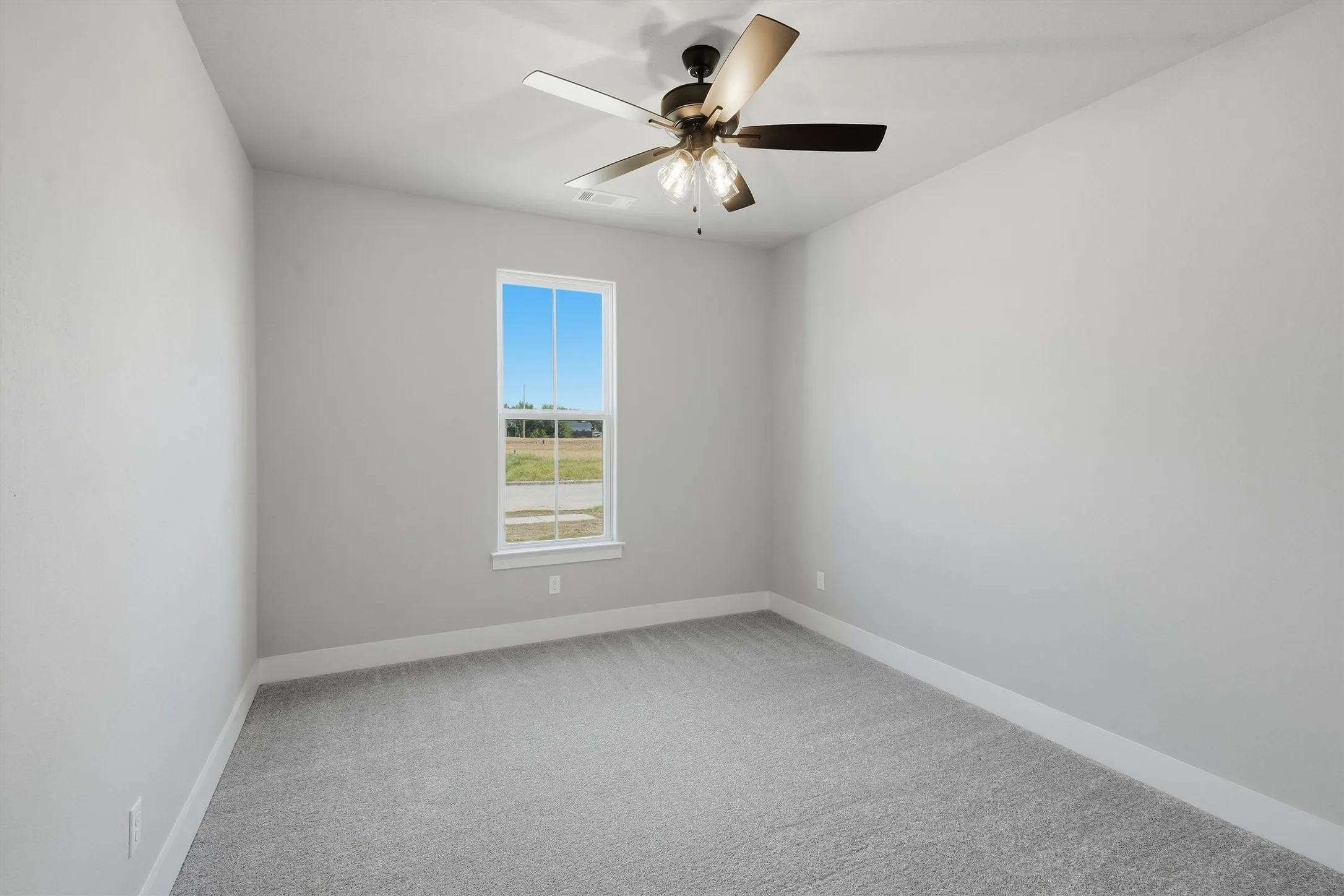 Recessed window with white trim, light gray carpeting, and a ceiling fan with integrated lighting