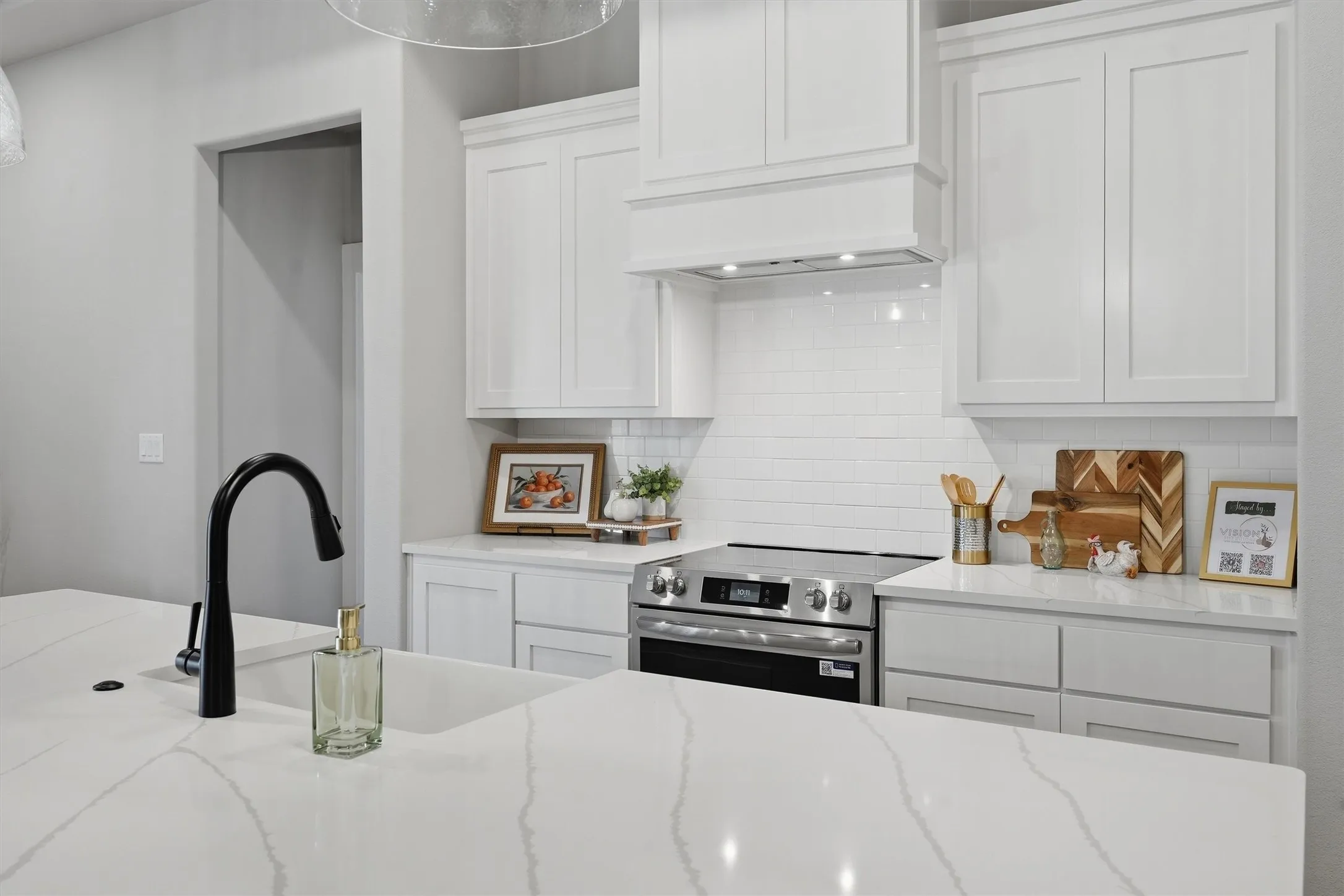 Kitchen featuring white shaker cabinetry, stainless steel range, white subway tile backsplash, white countertops, and a black gooseneck faucet
