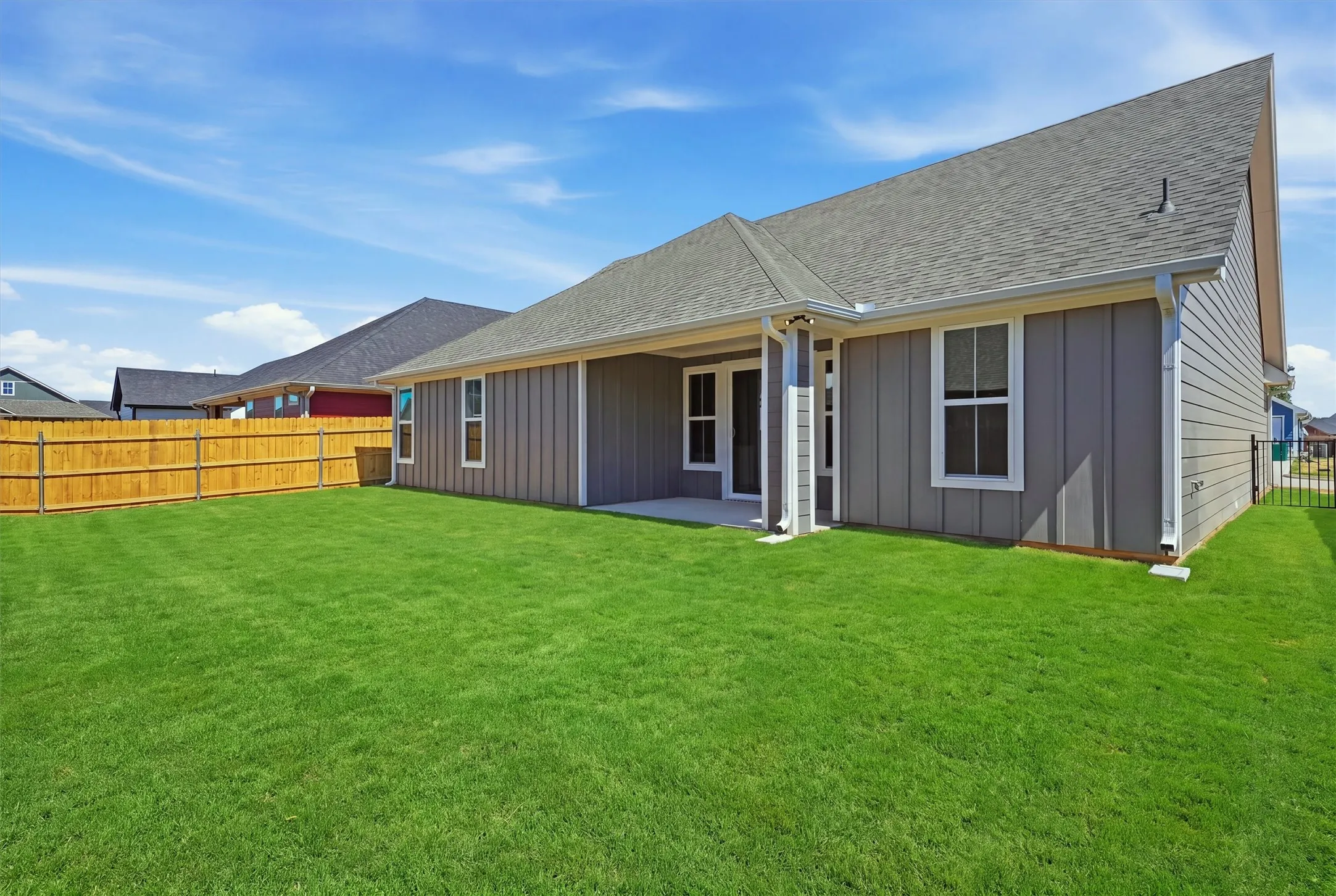 Expansive green lawn with a wood privacy fence