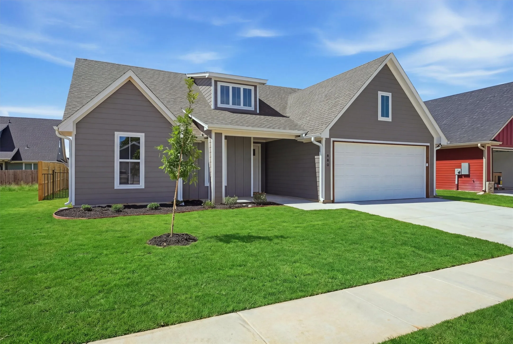 Gray siding exterior with white trim, a gabled roof, and a single dormer