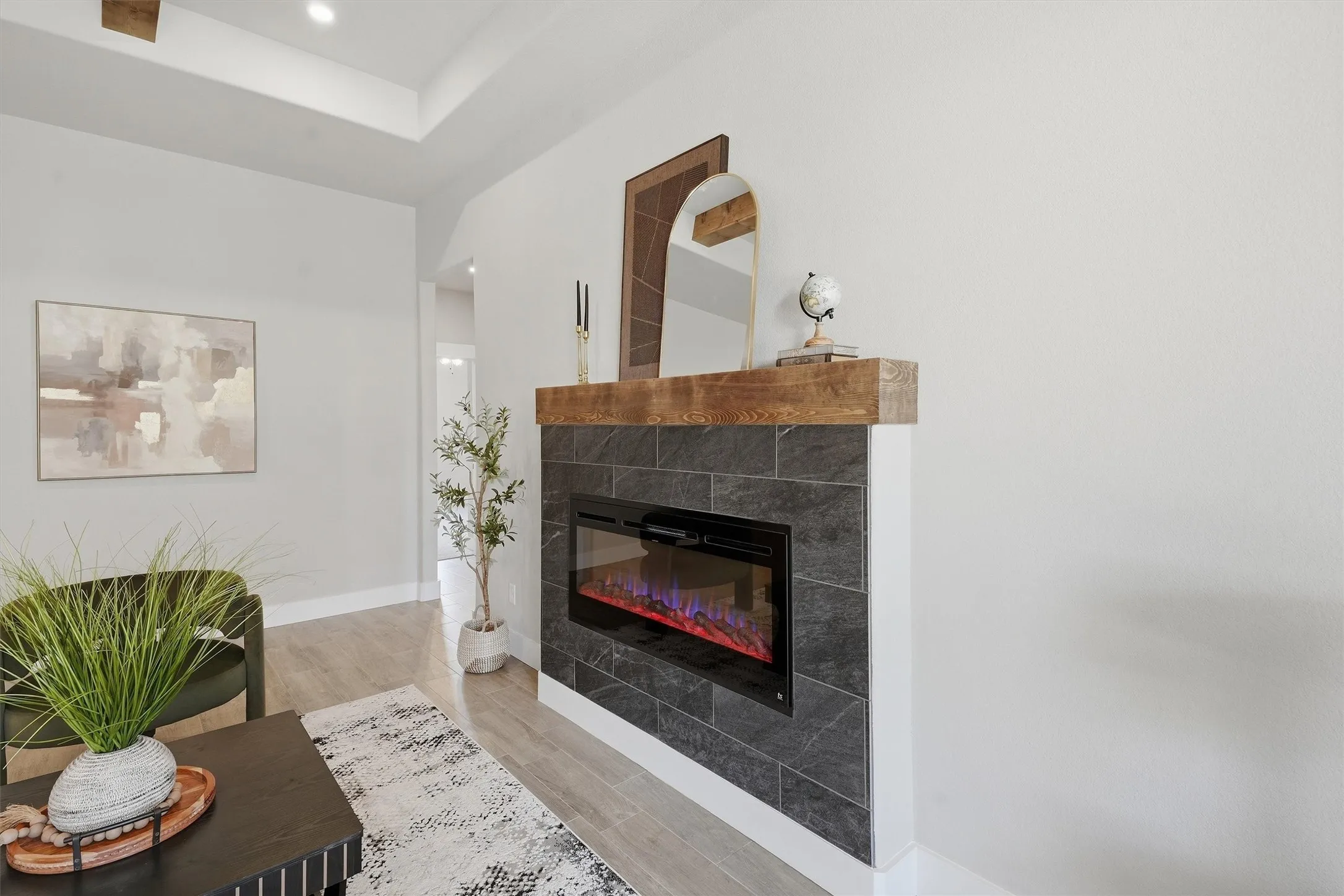 Integrated electric fireplace with dark tile surround and a wood-finish mantel