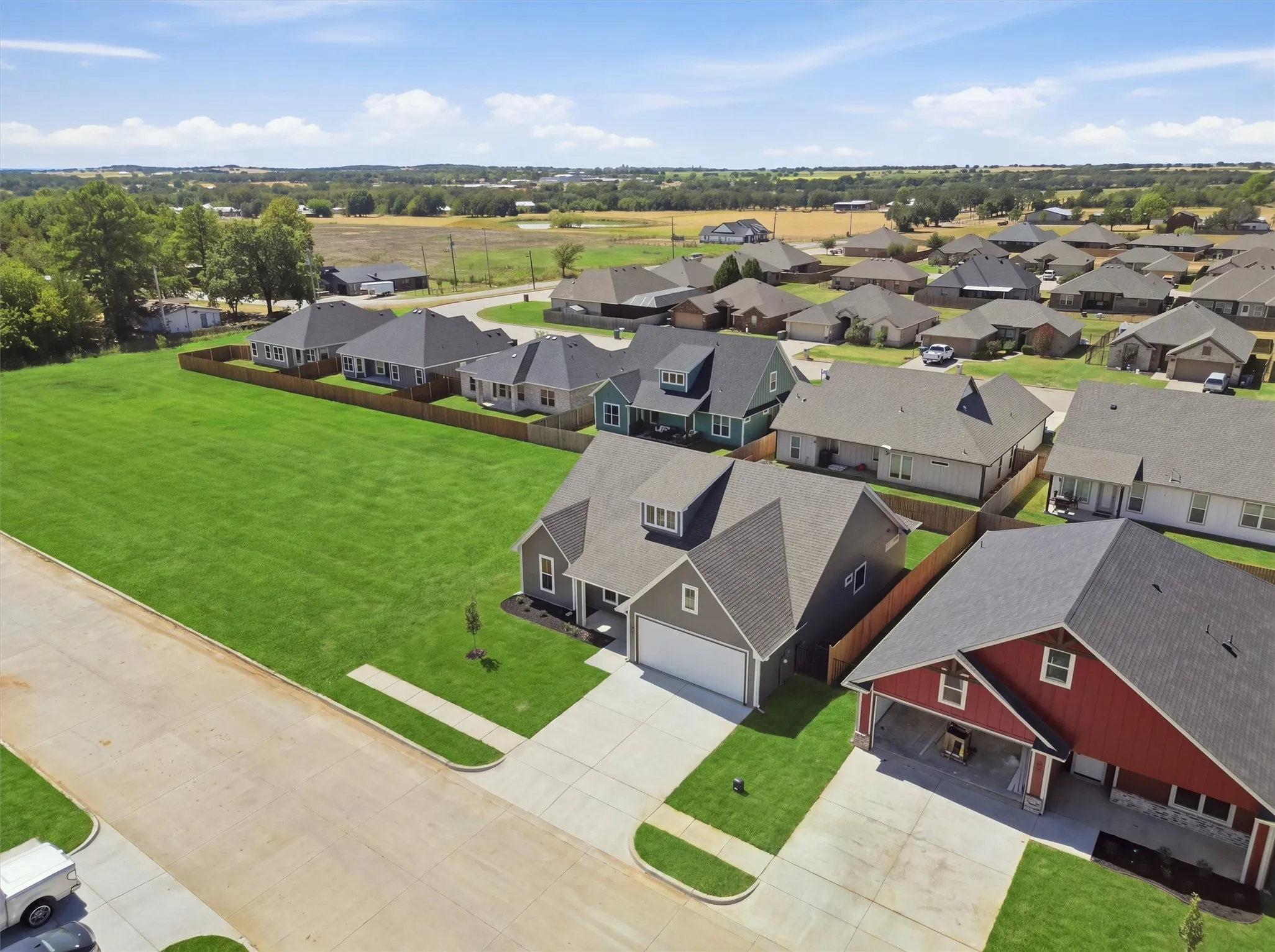 Expansive grassy lot, paved street access, and clear skies