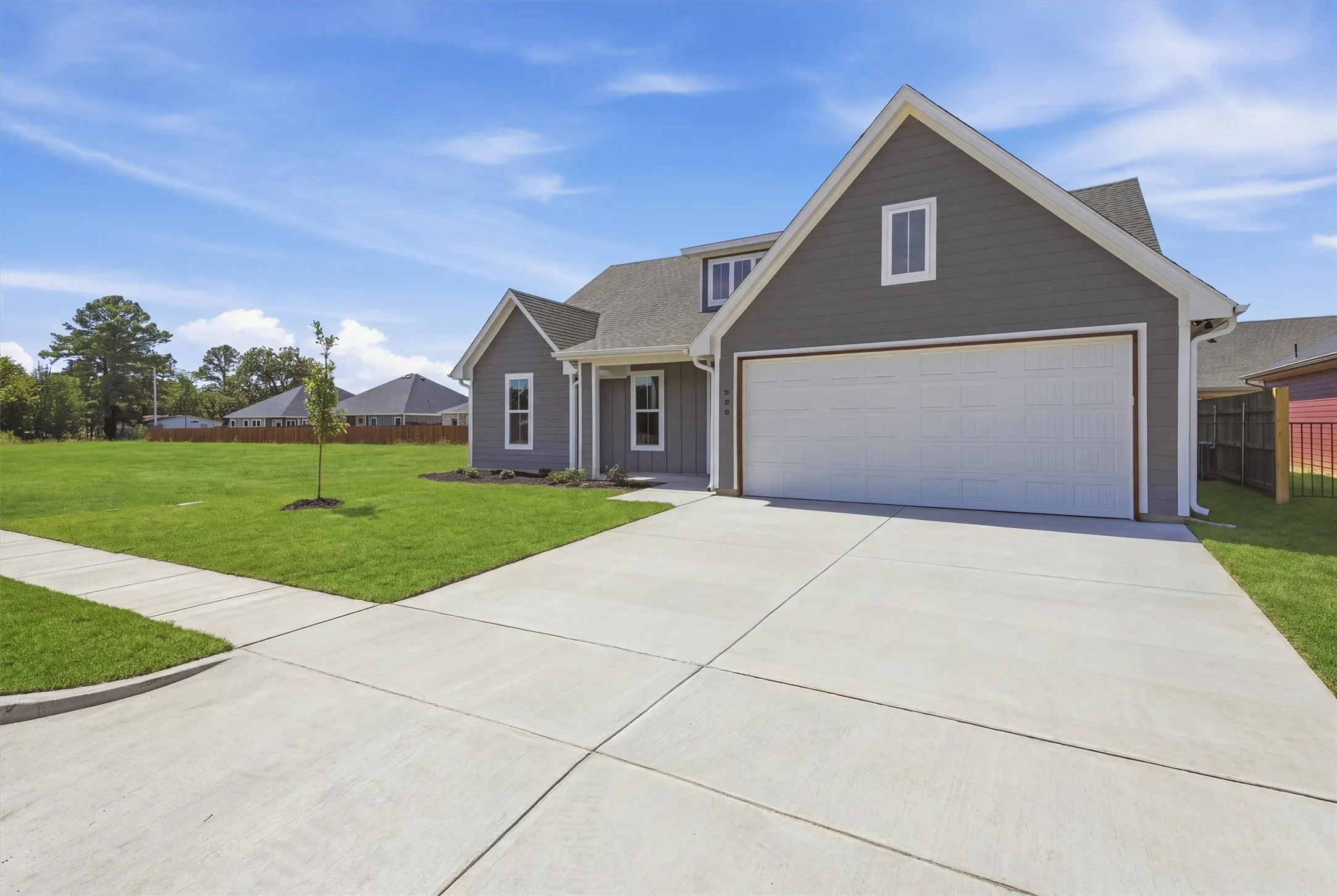 Contemporary-style exterior with gray siding, white trim accents, and an attached two-car garage