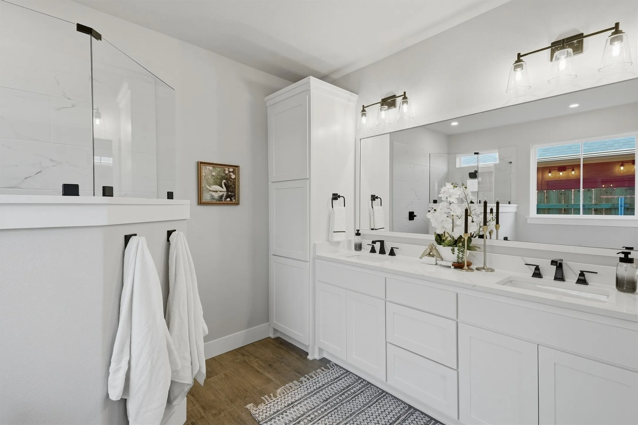 Dual vanity with undermount sinks, white cabinetry, and a full-width mirror