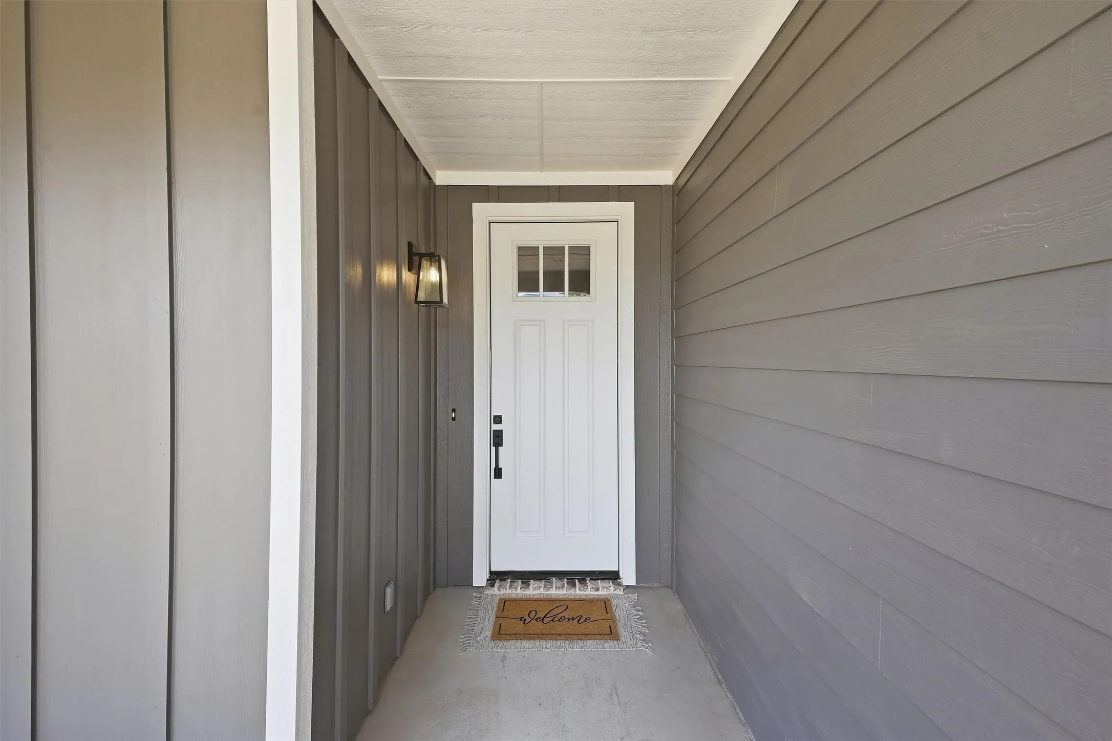 Covered entryway featuring board-and-batten and horizontal siding