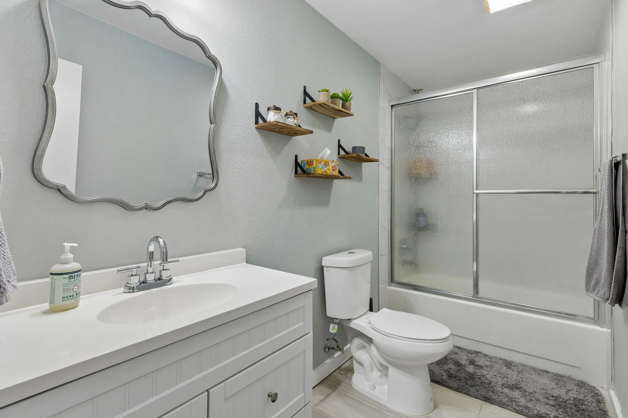 Updated Secondary Bath - An updated vanity, framed mirror, refreshed fixtures, tile flooring, and a tiled tub-and-shower surround give this bath a clean, polished feel with practical everyday function.