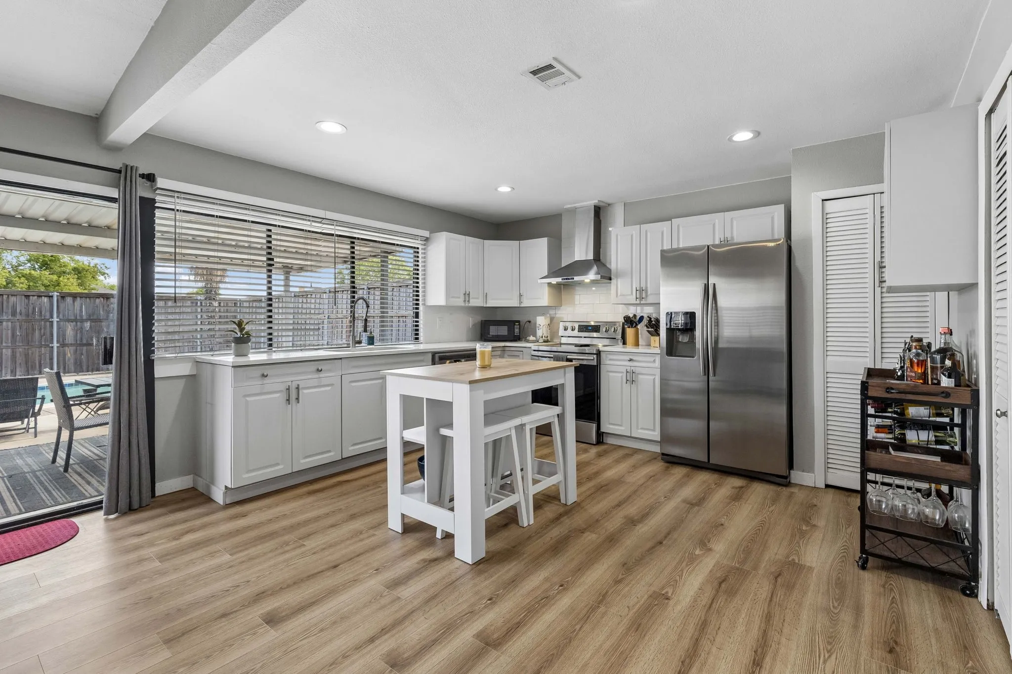 Kitchen with Poolside Connection - An open layout, generous counter space, and nearby sliding doors make it easy to move from meal prep to the covered patio and pool for effortless indoor-outdoor living.