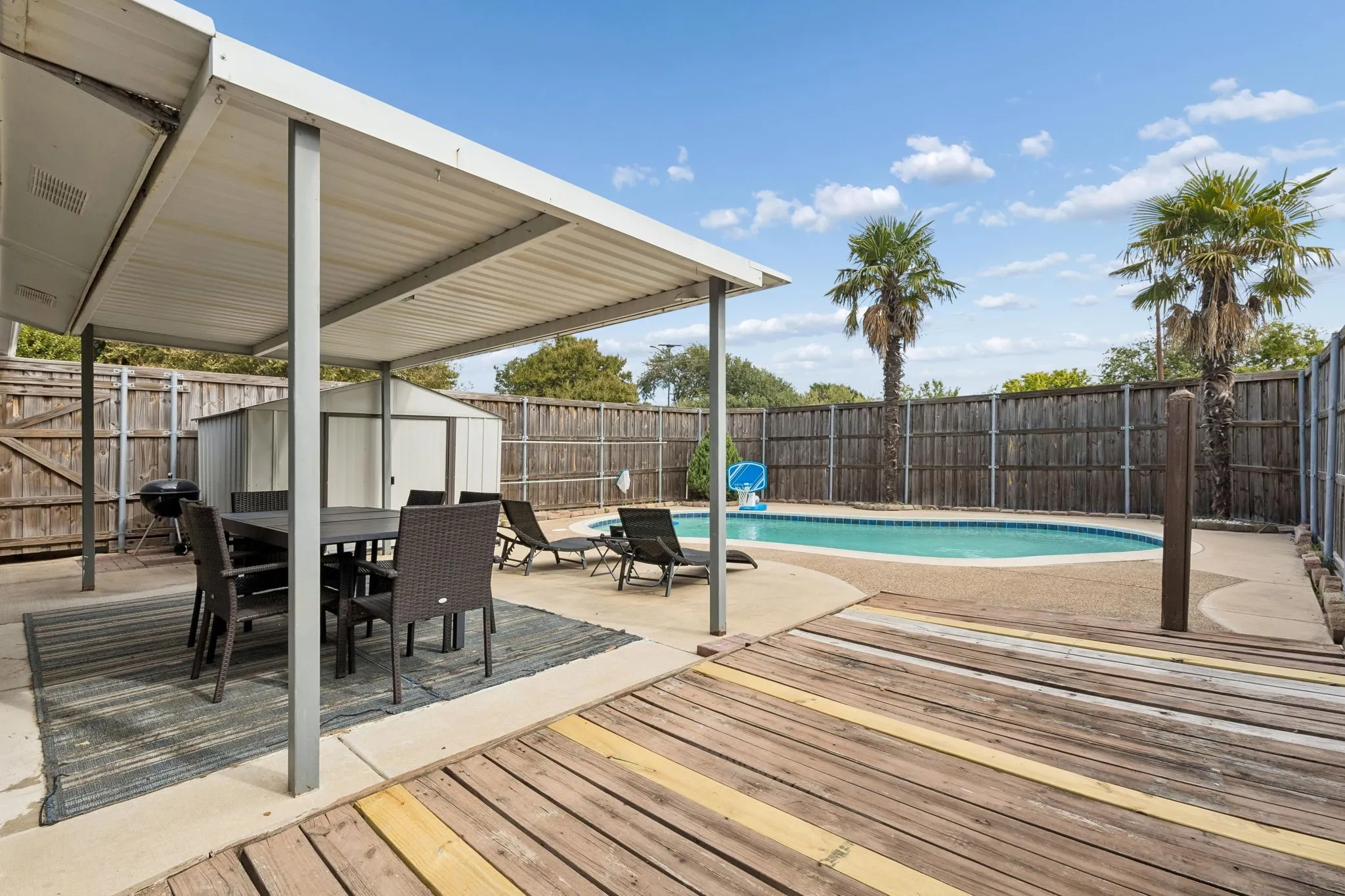 Designed for Easy Outdoor Enjoyment - A low-maintenance backyard brings together the pool, covered patio, deck space, privacy fencing, and storage for a setting made for effortless outdoor living.