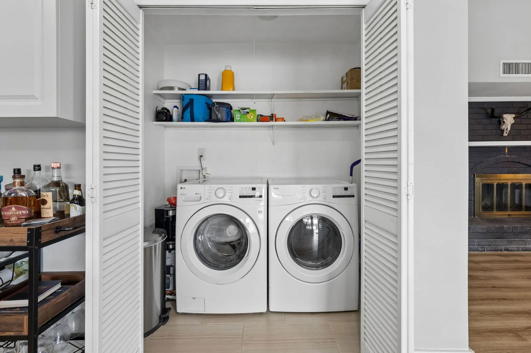 Conveniently Placed Laundry - A dedicated laundry closet with built-in shelving keeps household essentials organized while placing everyday functionality within easy reach of the main living areas.