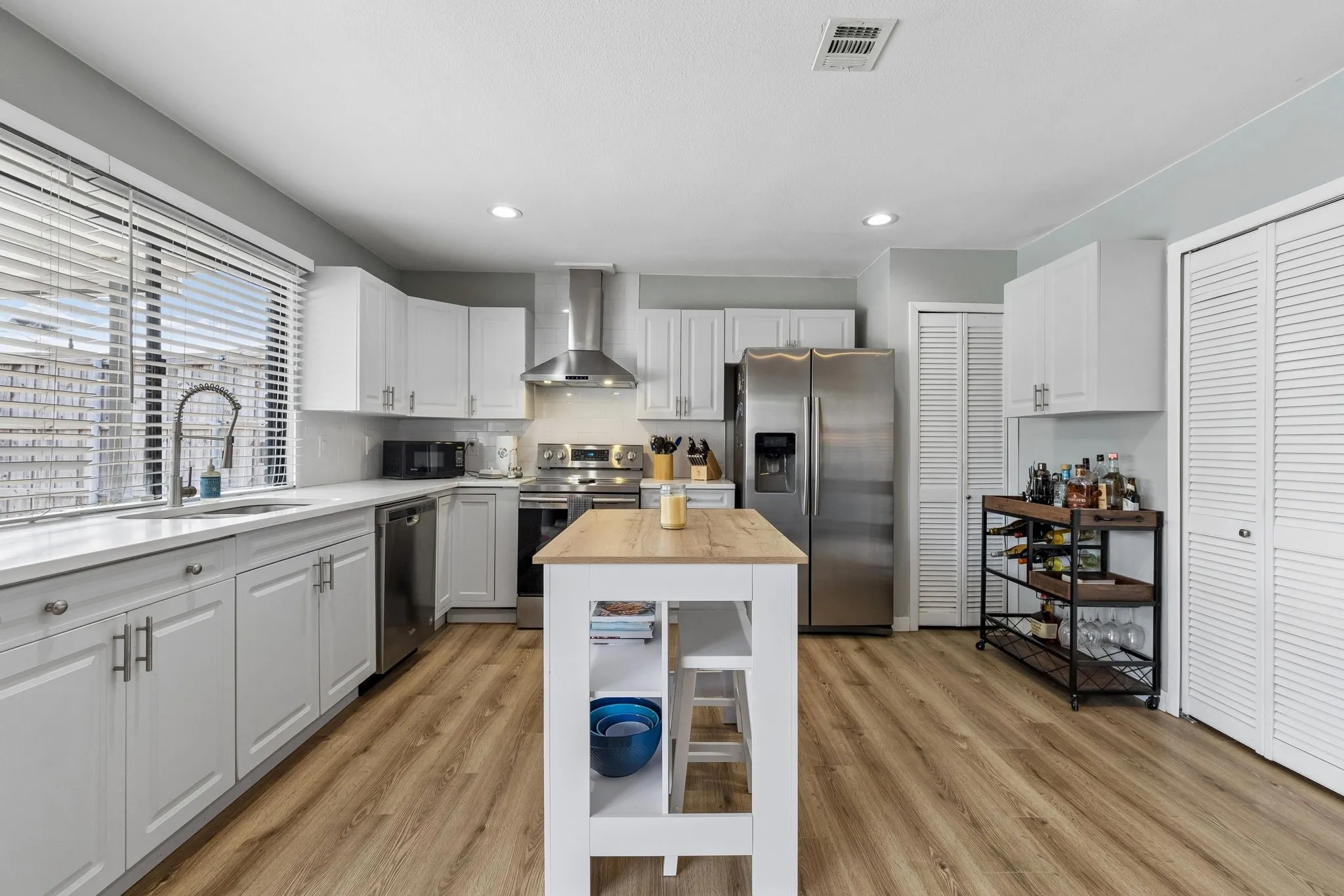 Bright, Functional Kitchen - White cabinetry, quartz countertops, stainless appliances, updated hardware, and LED lighting create a crisp workspace with abundant storage and room to move.