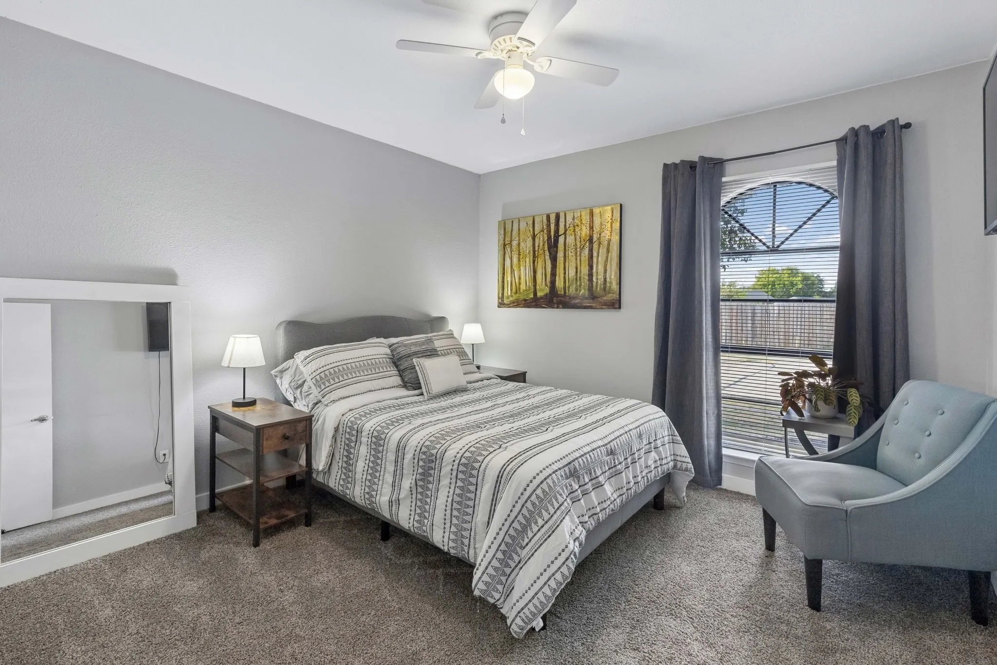 Bright Secondary Bedroom - An arched window brings architectural character and natural light into this carpeted bedroom, while the simple layout offers flexibility for a variety of uses.