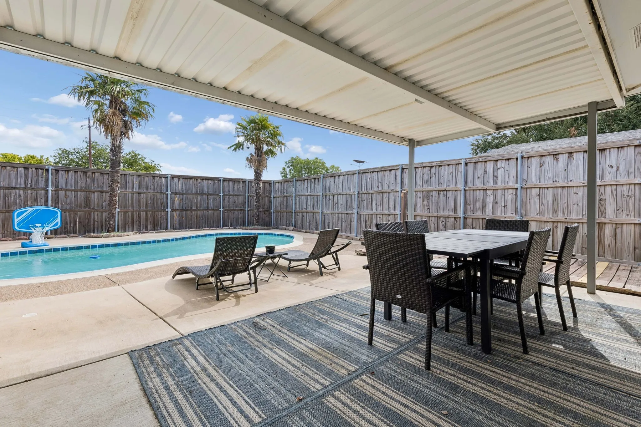 Poolside Outdoor Living - The freshly resurfaced pool and new water-level tile create a crisp backyard focal point, while the covered patio offers a shaded extension of the home for dining, relaxing, and enjoying the outdoors.