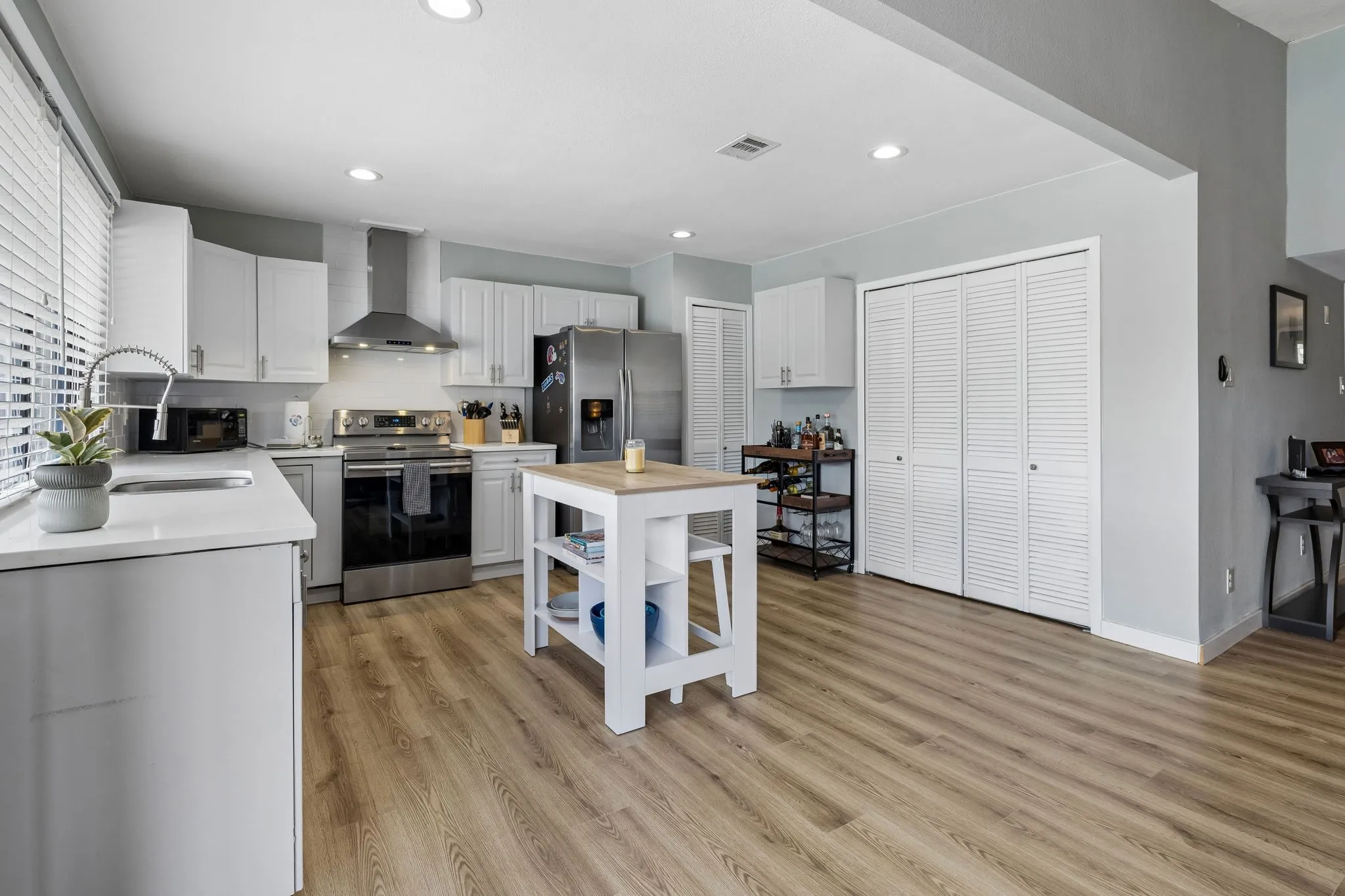 Clean, Open Kitchen Design - Quartz countertops, white cabinetry, stainless appliances, LED lighting, and generous floor space create a bright, functional kitchen designed for easy everyday use.