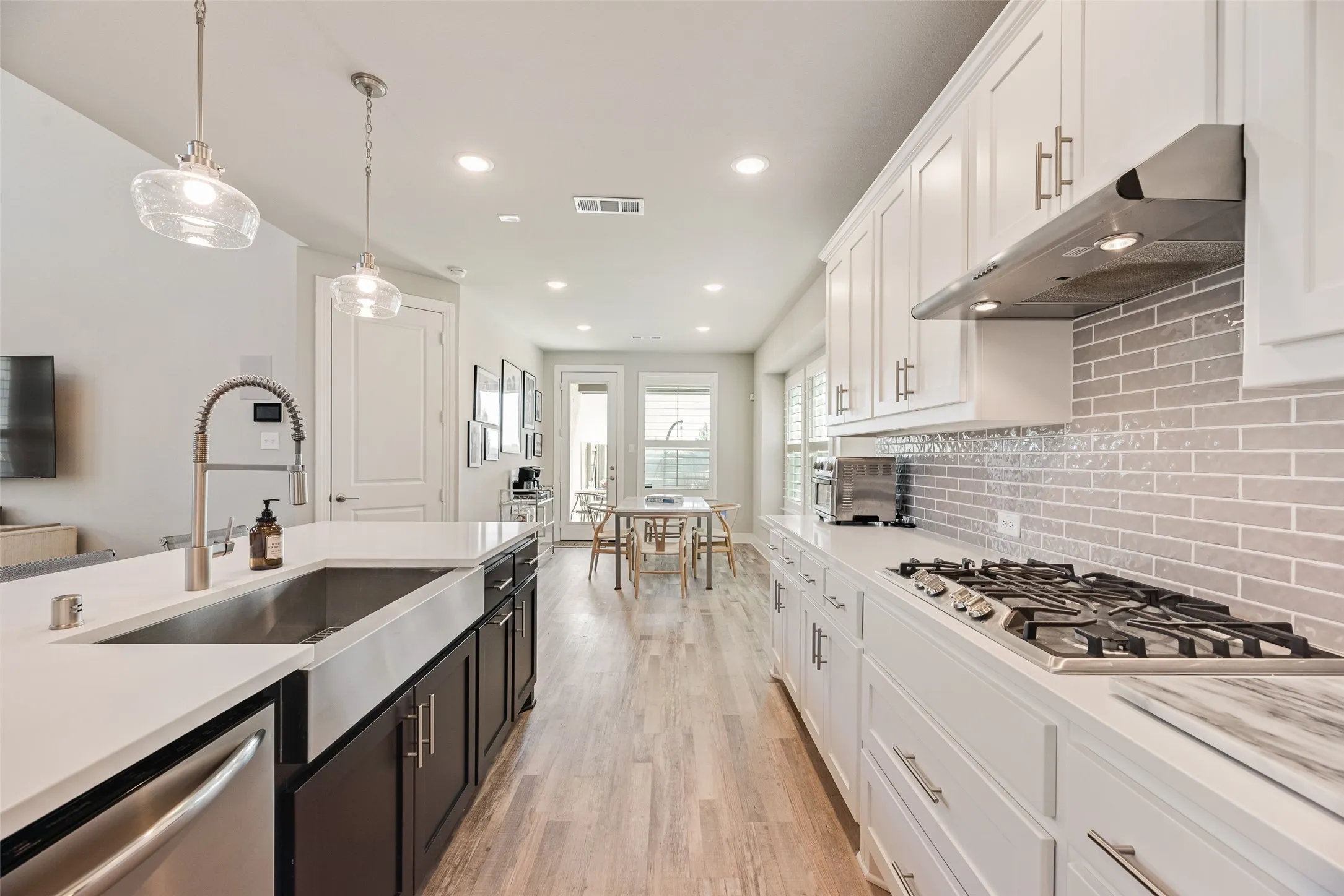 Modern kitchen featuring an undermount sink, stainless steel appliances, a gas cooktop, and a subway tile backsplash
