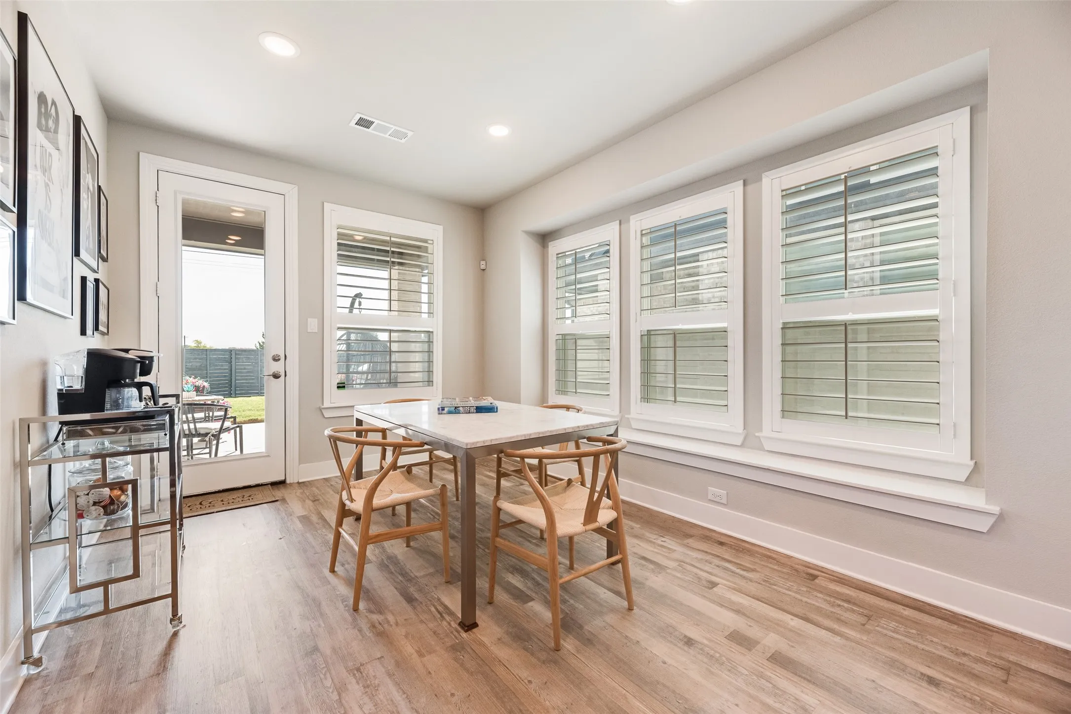 Wood-finish flooring, recessed lighting, and multiple windows with plantation shutters