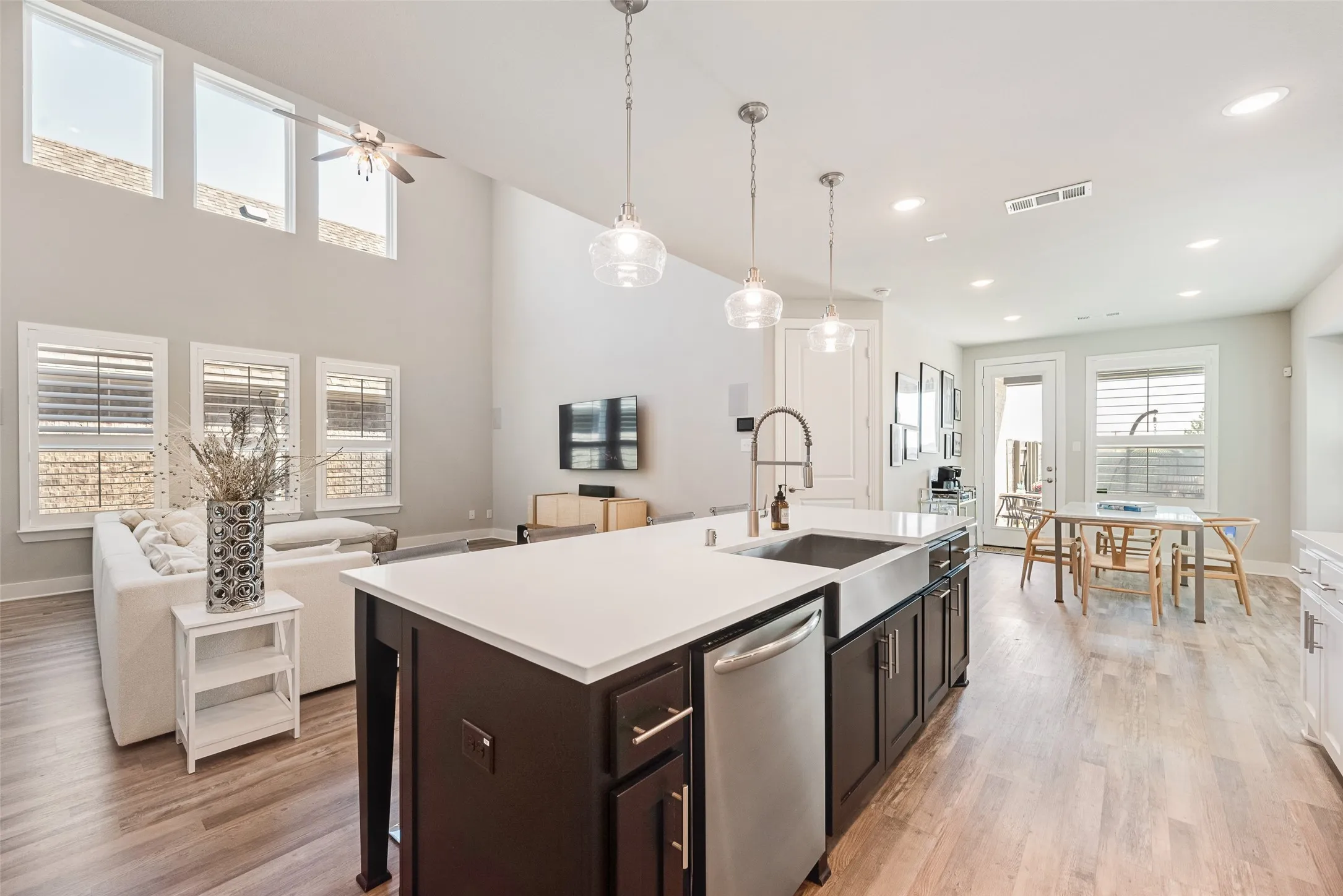 Kitchen island featuring a stainless steel farmhouse sink and dishwasher