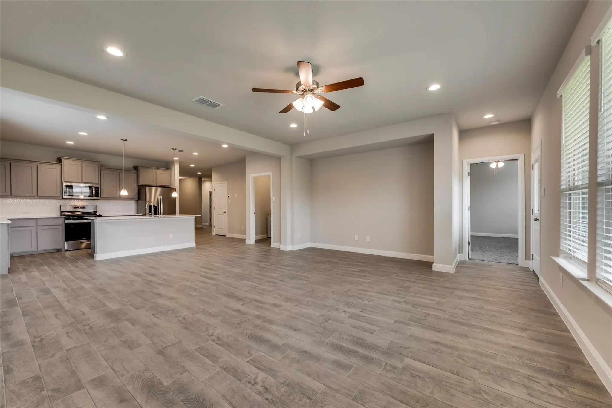 Unfurnished living room with light hardwood / wood-style floors and ceiling fan