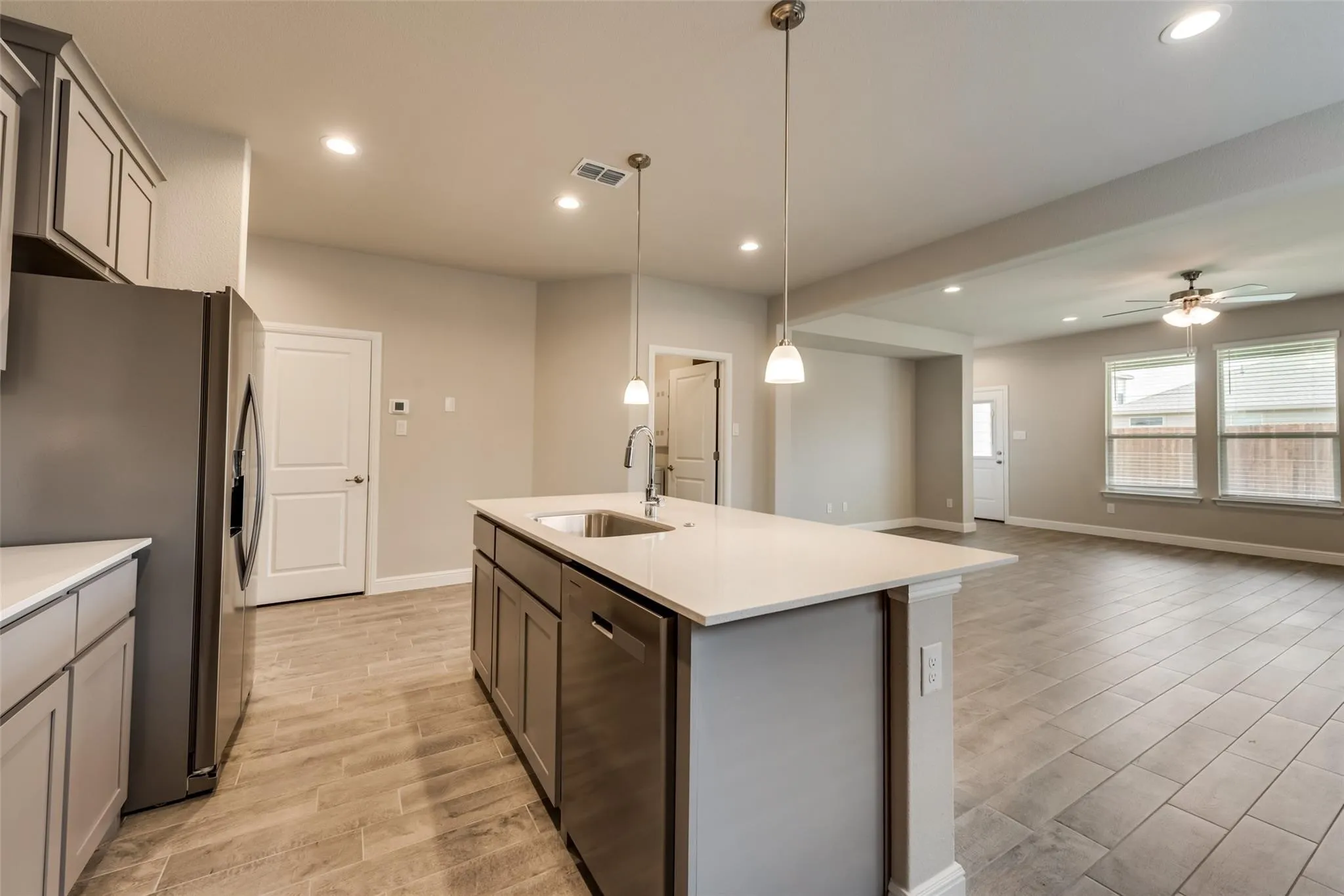 Kitchen featuring appliances with stainless steel finishes, gray cabinetry, sink, hanging light fixtures, and ceiling fan