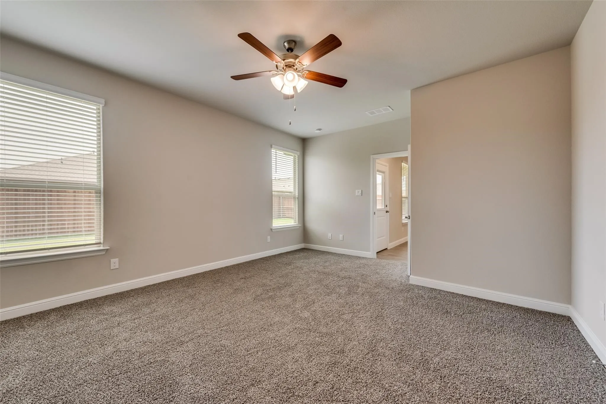 Empty room with carpet floors and ceiling fan