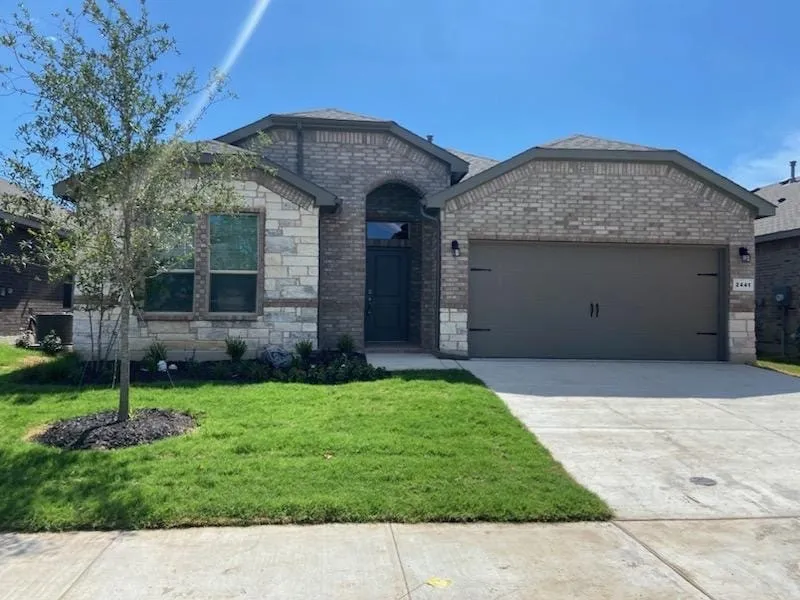 View of front of house featuring a garage and a front yard