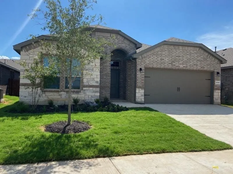View of front of home featuring a garage and a front lawn