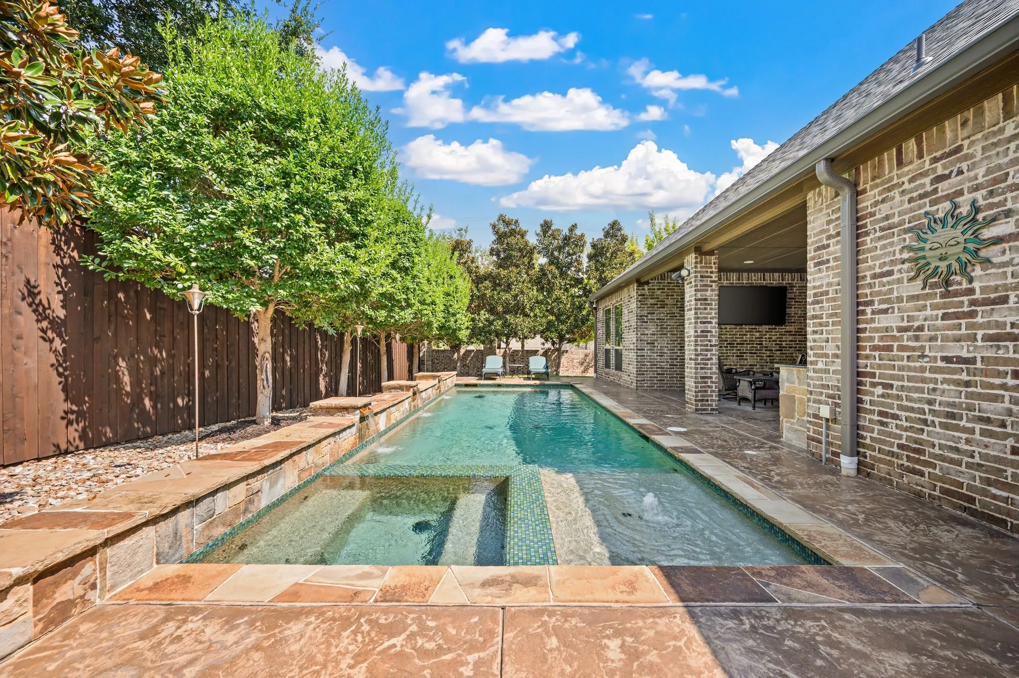 Swimming pool with integrated spa and stone coping