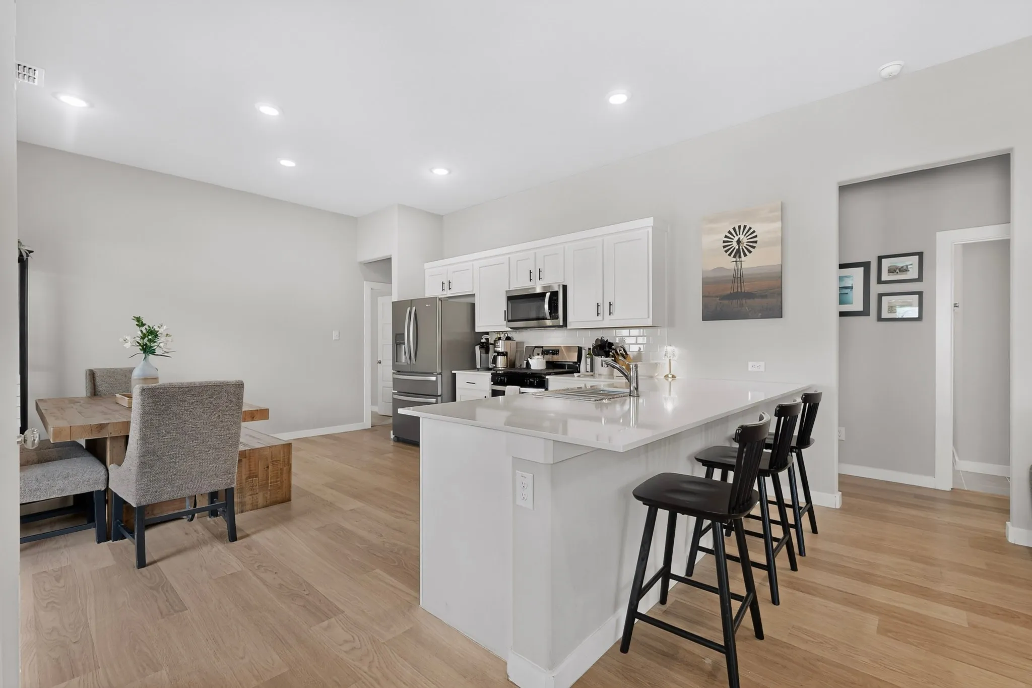 Kitchen featuring a central island with countertop seating, white cabinetry, and stainless steel appliances