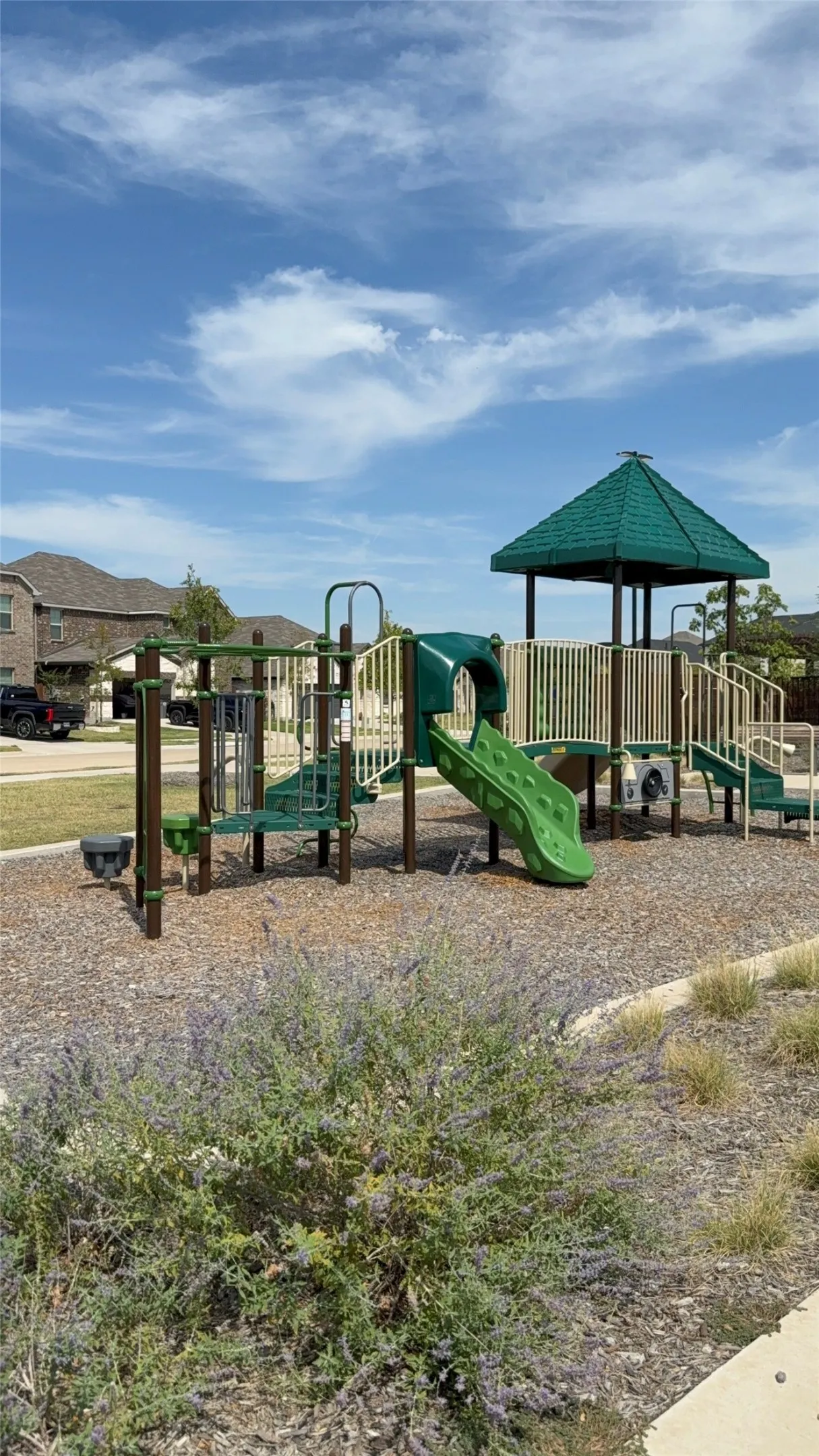 Community playground with multi-level structures, slides, and shaded seating area