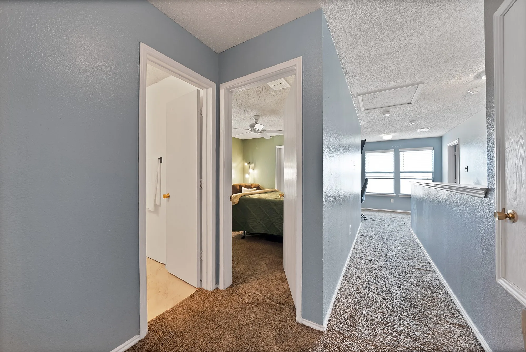Hallway featuring a built-in half wall, access panel, and wall-mounted lighting