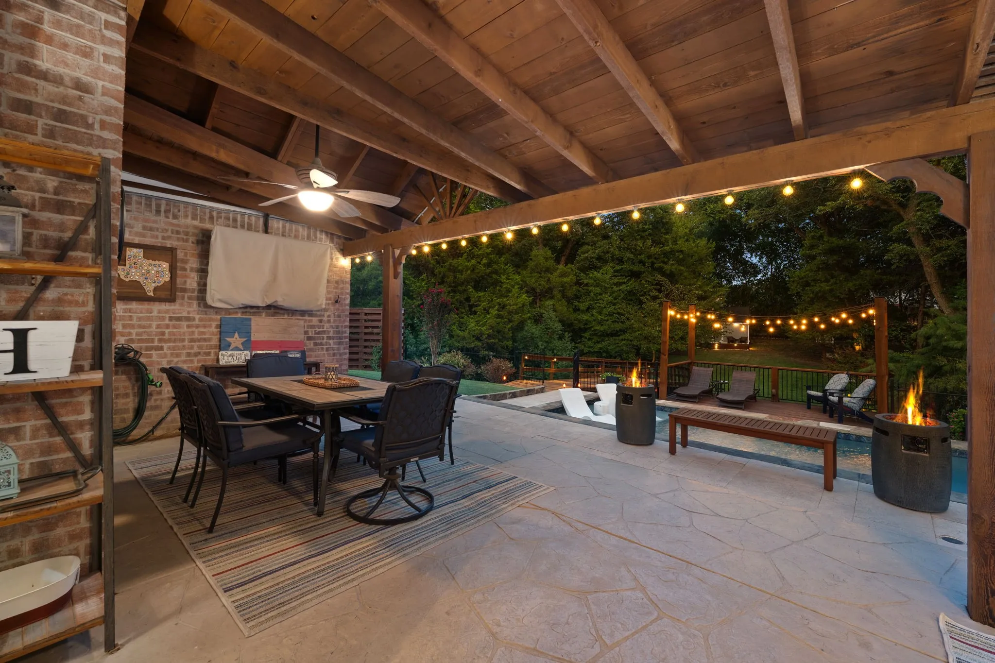 Covered patio with a wood-beam ceiling, stamped concrete patio with view of pool and backyard