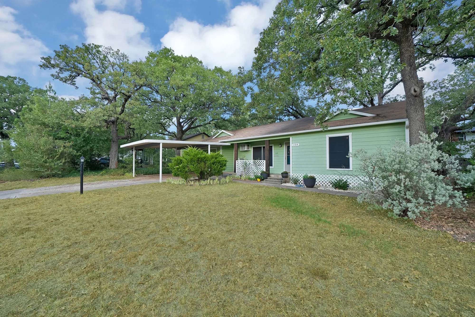 Light green siding exterior with a brown shingle roof